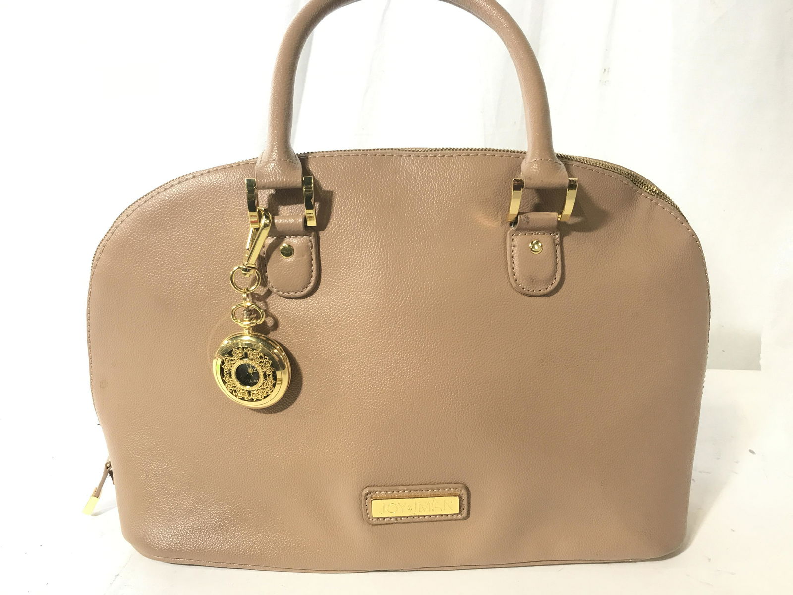 JOY and IMAN 21Section Leather Handbag and Watch: 100% pebble & split leather, taupe color handbag. Zipper around sides & top, accent key chain/ pocket watch. Will need battery. Measures 15.5 x 10 in. Width/ depth 5 in. Shiny Polyester lining. Light