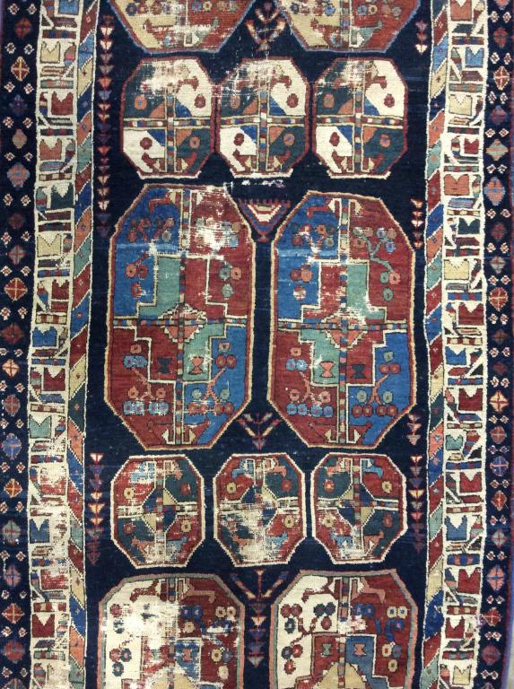 Vintage Handmade Turkish Wool Runner: Rug is vintage Possibly antique. Rug is wool and handmade. Piece has multi toned floral leaf and vine detail with tones of cranberry, green, purple, chocolate, beige, & Slate. Rug measures approx 140 