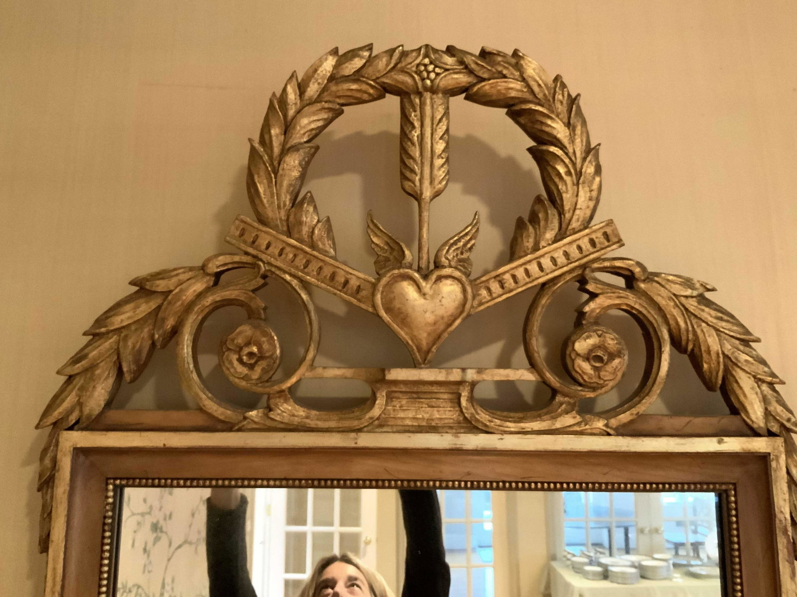 1/2 hand carved gilded grand Wall Mirror: Unusual one of pair grand mirrors hand carved gilded with crown of arrow and heart, in situation are flaking doorway above matching commodes, possibly antique, richly carved, each measures ht 48 inche