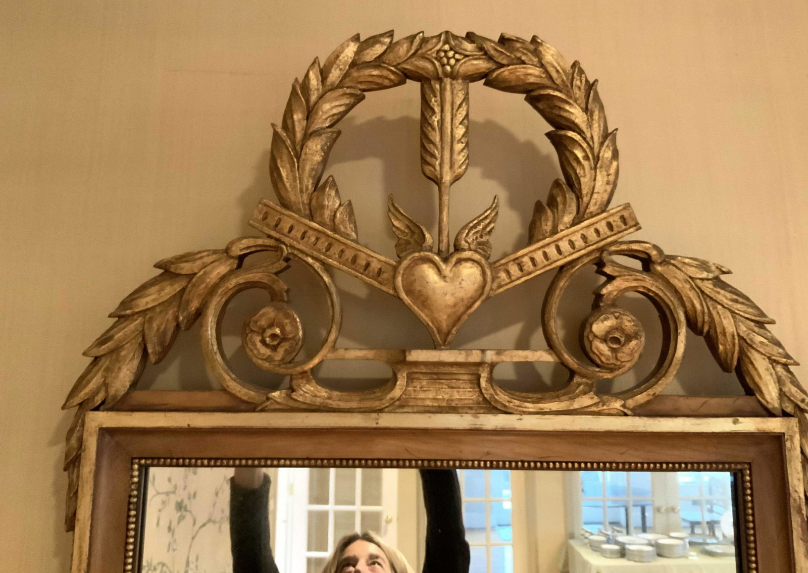 1/2 Hand Carved Gilded Grand Wall Mirror: Unusual one of pair for auction, grand mirrors hand carved gilded with crown of arrow and heart, in situation are flaking doorway above matching commodes, possibly antique, richly carved, each measure