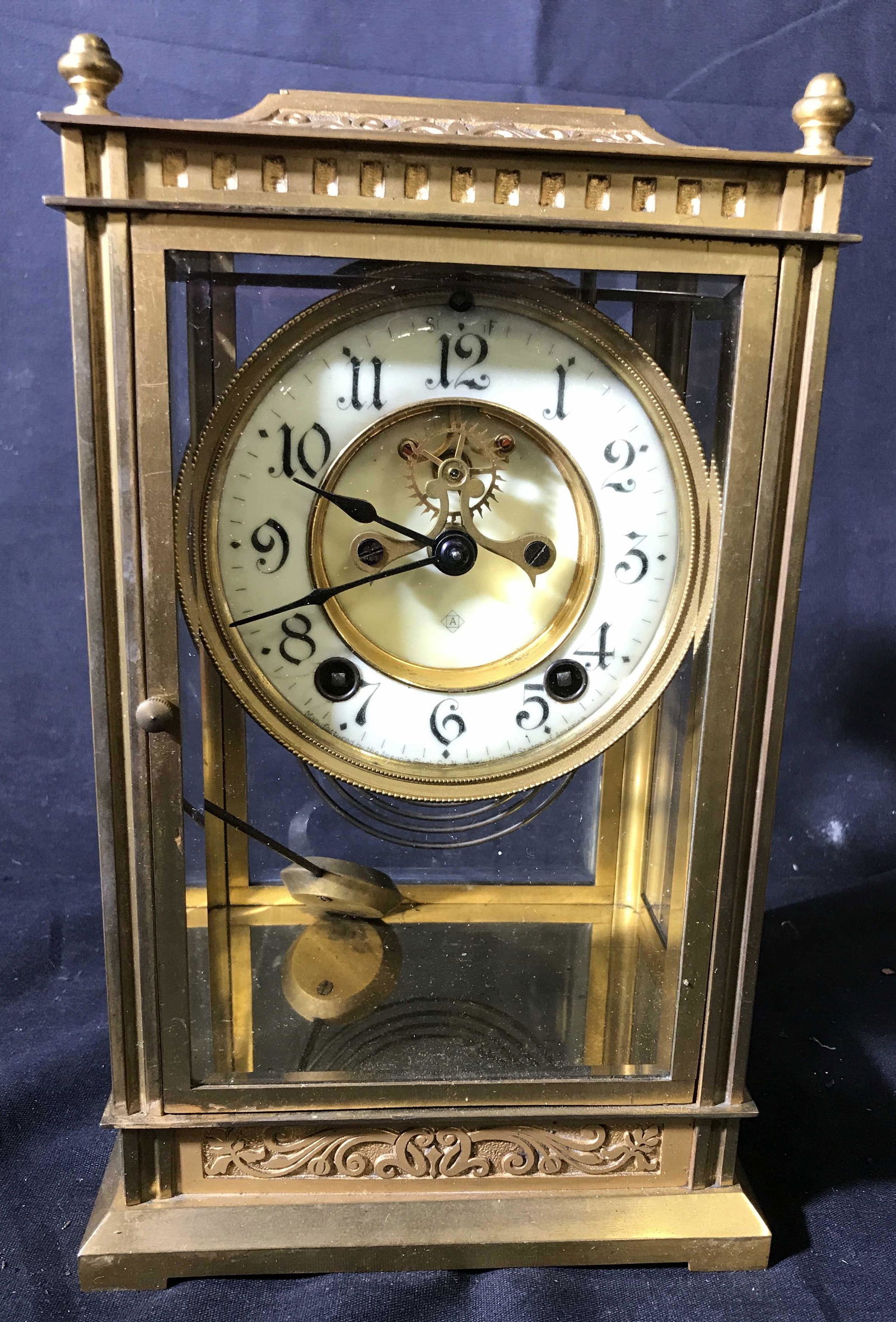 Gilded teal Mantle Clock: Glass and gold toned metal framed clock, porcelain face, vintage possibly antique clock, measures app 10.5 inches by 6 inches by 6 inches