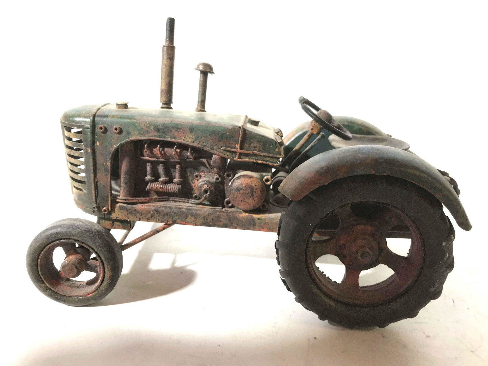 Antique Metal Tractor Toy: Collectible painted metal tractor, moveable wheels, steering wheel and more, antique condition measures app ht 7 inches, length 10 inches, width 6 inches