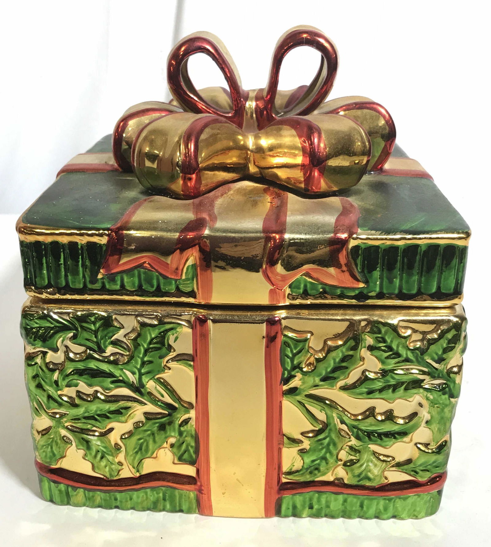 Vintage Hand-painted Ceramic Christmas Cookie Jar: This is a hand painted cookie jar, the piece has been crafted to resemble a Christmas present. The piece is colored in metallic red, and green tones as well as gilt paint. The piece measures approx 6