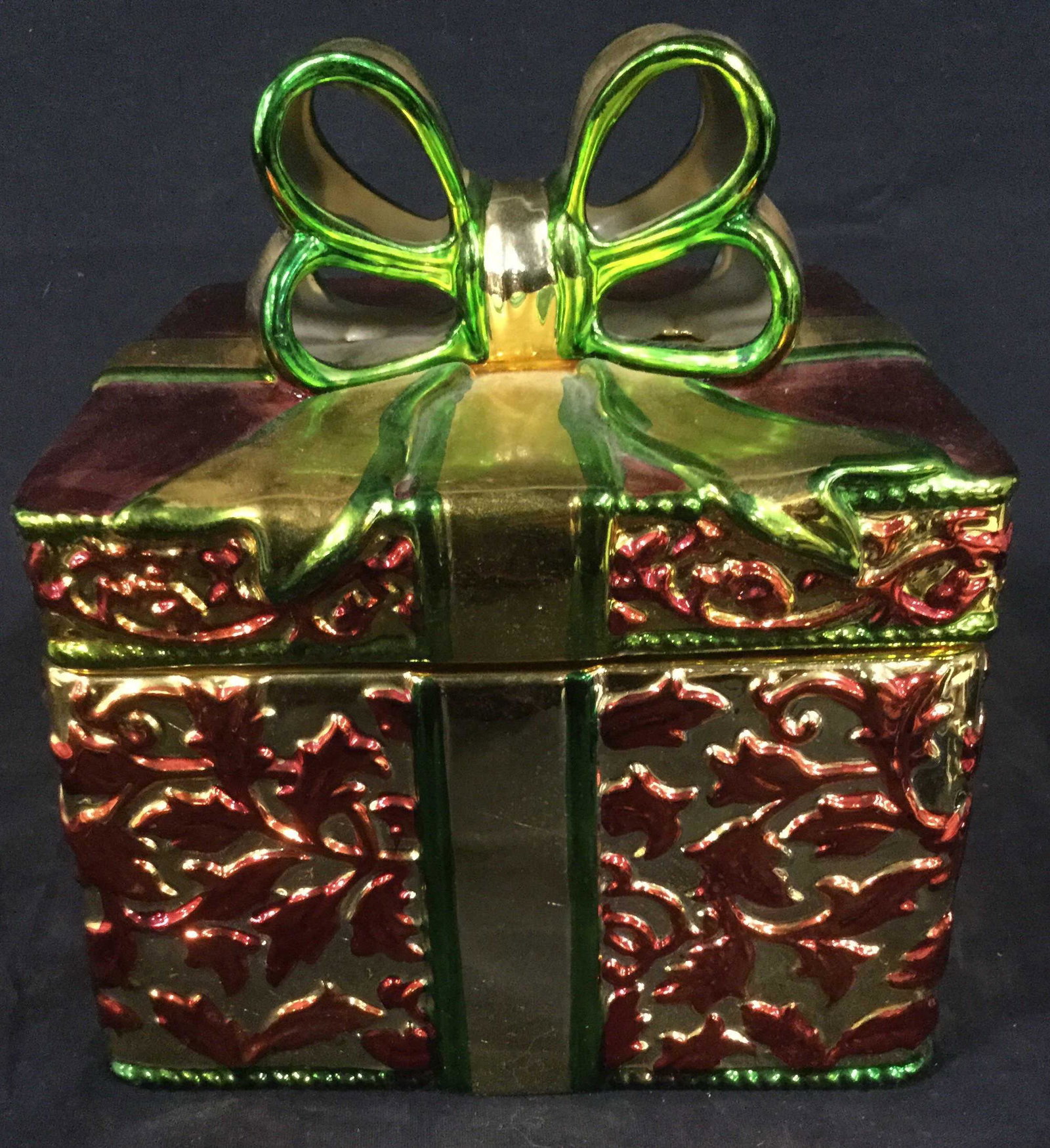 ENAMEL and PORCELAIN Cookie Jar: Ceramic holiday box with enamel painting and embossed texture. Box function like a present with a lip on top. Decorative lid has decorative enamel painted bow. Tabletop accessory, functional. Without 