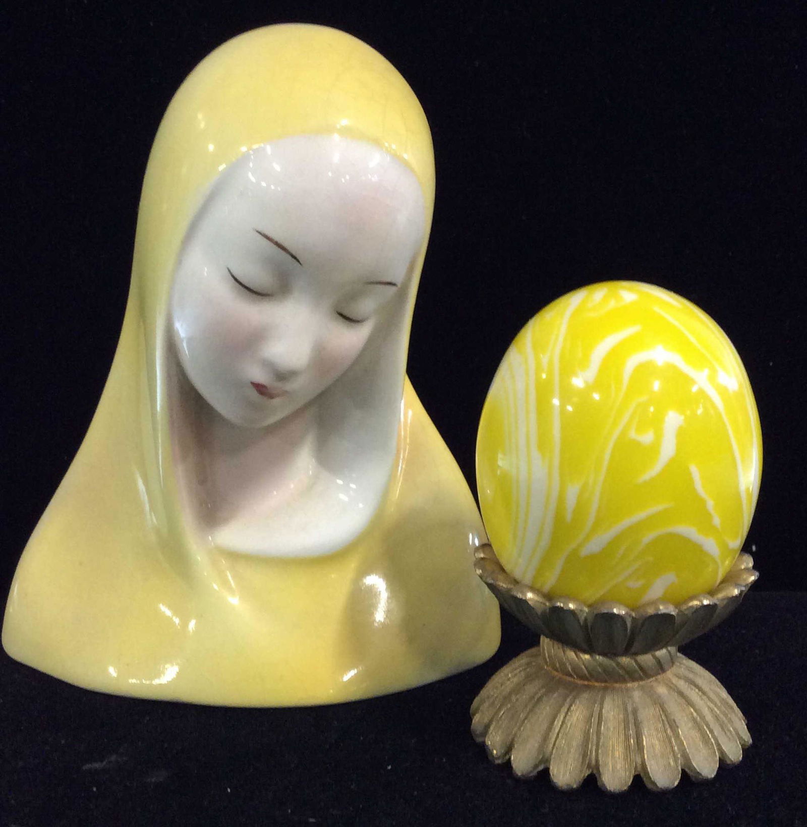 Lot 2 Fine China, Yellow Tabletop Decor: Goldscheider Everlast Corp Fine China Figural Of woman draped with cloth over head. Light Crazing to one size, yellow paint w/ glaze, hallmarked, 4 x 4.25 in. Marbilized Acrylic Yellow Egg On Brass To