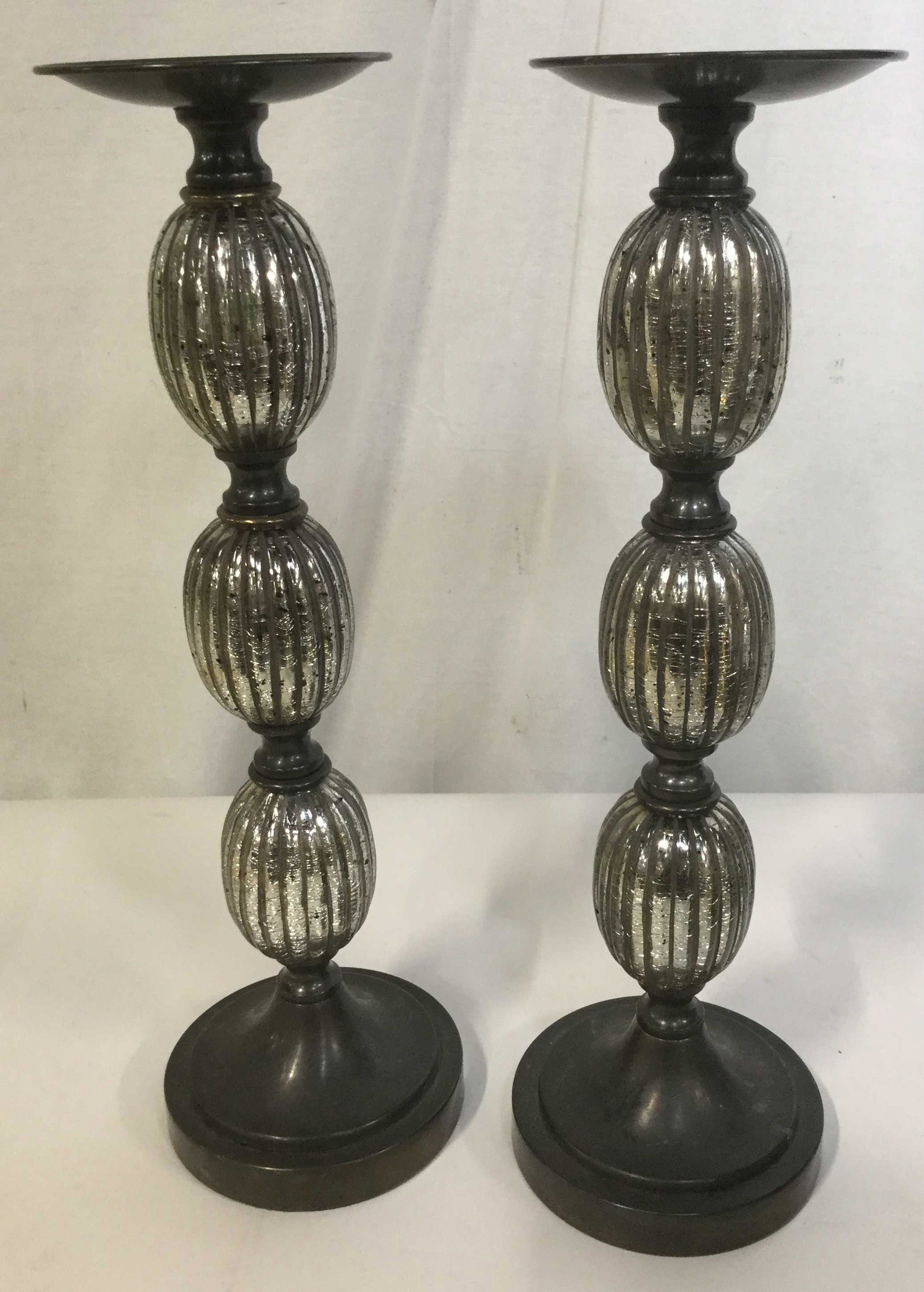 Set of 2 Large Silver Toned Candle Pedestals: Set of two oversized Art Deco inspired candle pedestals paint silver toned detailing. Each \pedestal measures 19 inches tall and 5 inches across at the pedestal. Home decor, mantle piece decor, decora