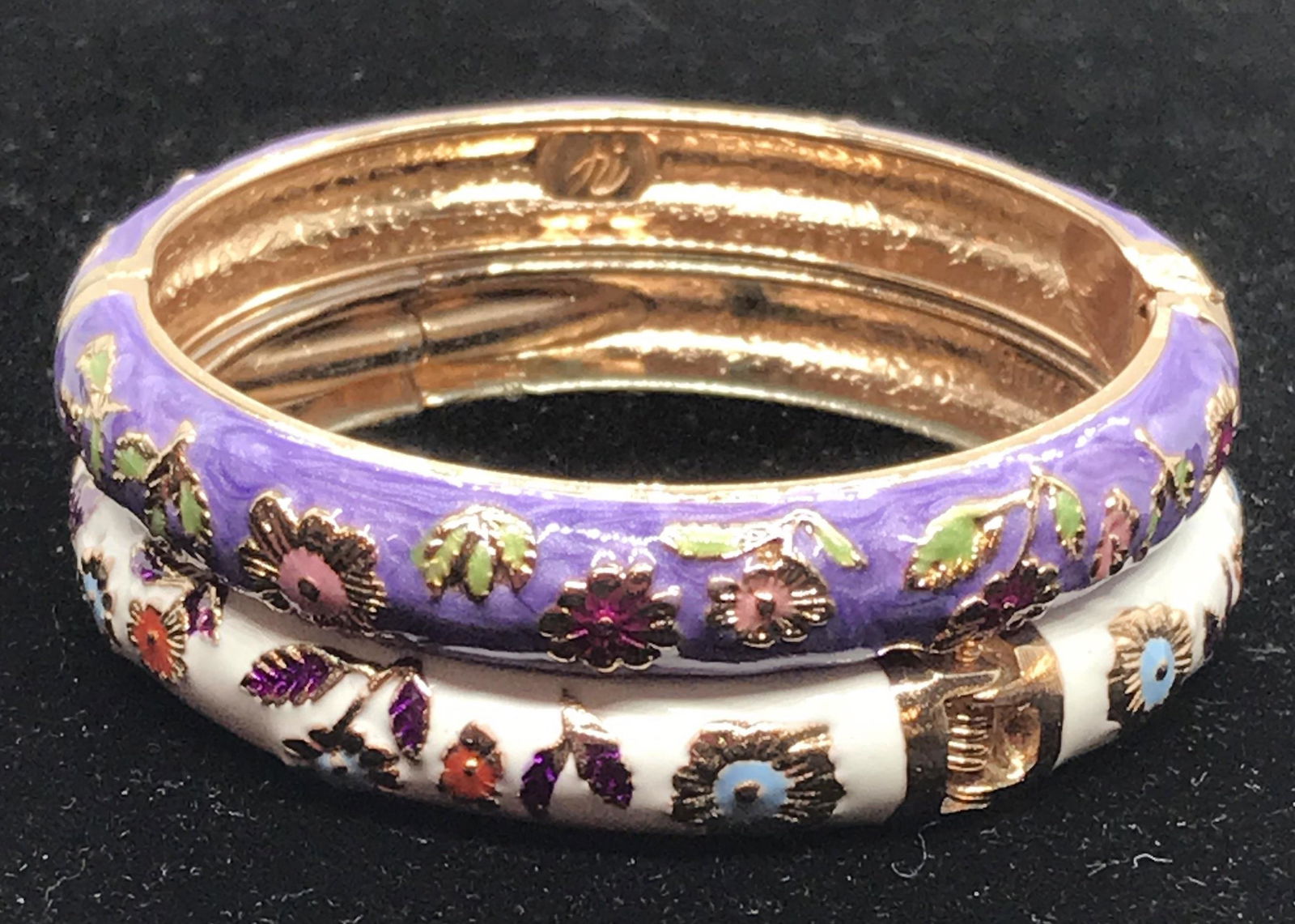 Pair Jiu Long Xing Asian Enamel Bagels: Hinged bangles, one white with rose gold tone outlined flowers, the other purple enamel with rose gold tone outlined flowers. Like new. Property of Upper East Side NYC Estate. 2 1/4 in. diameter. Asia