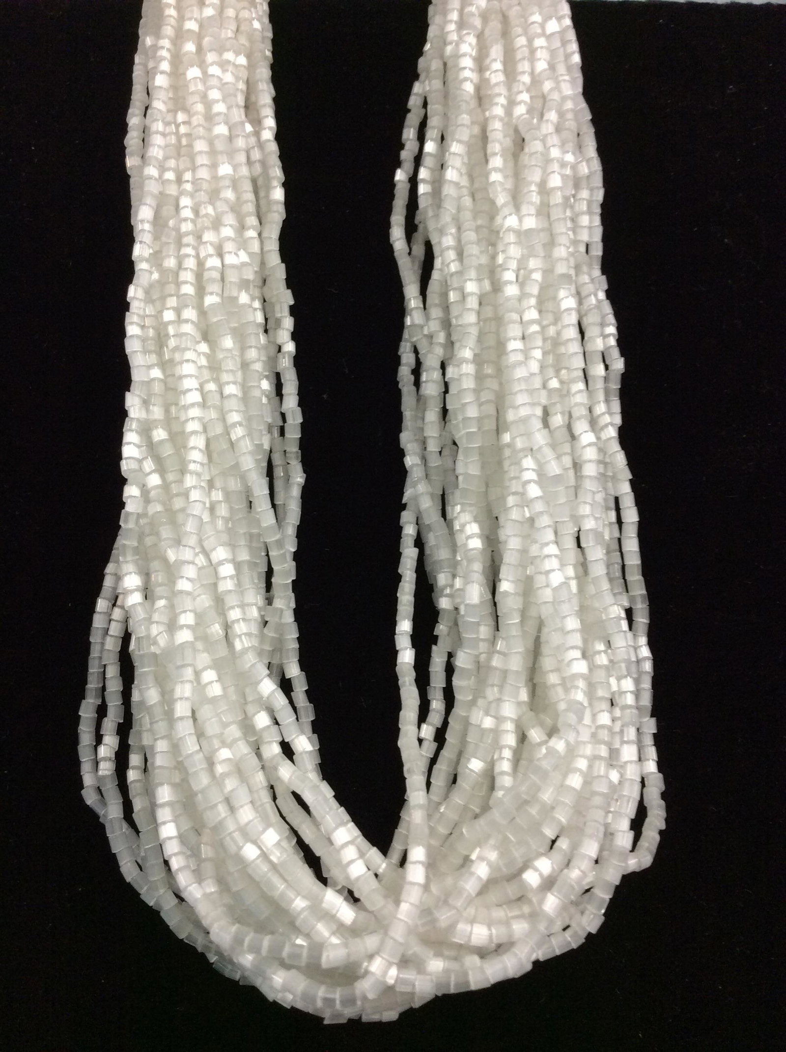 Adjustable Multi Strand Collar/Choker Necklace: Full of glistening white beads attached by a silver tone pierced hardware. Measures 16.25- 18 in. app. Over 10 strands of craftsmanship. Weighted piece around neck. Hooks over larger beads to secure. 