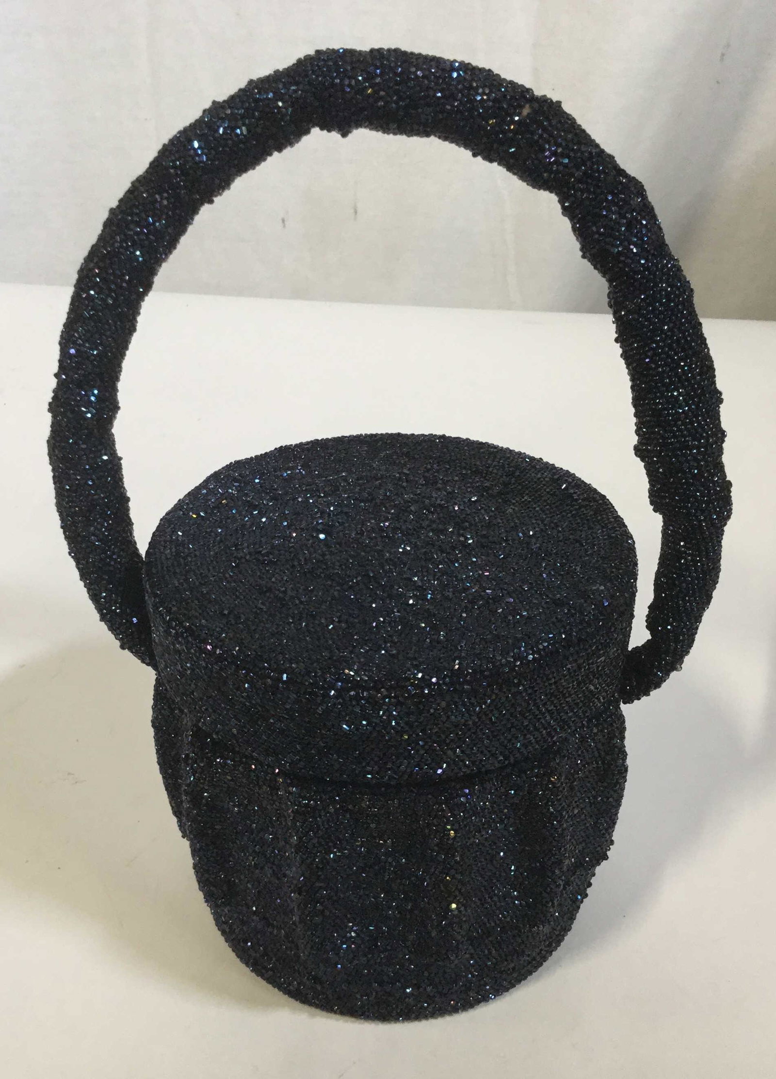 Round Blue and Black Beaded Purse: Round stout evening bag with lid closure. Bags exterior and handle are fully beaded with blue and black light catching beads. When the top of the purse is removed it features a mirror on the underside