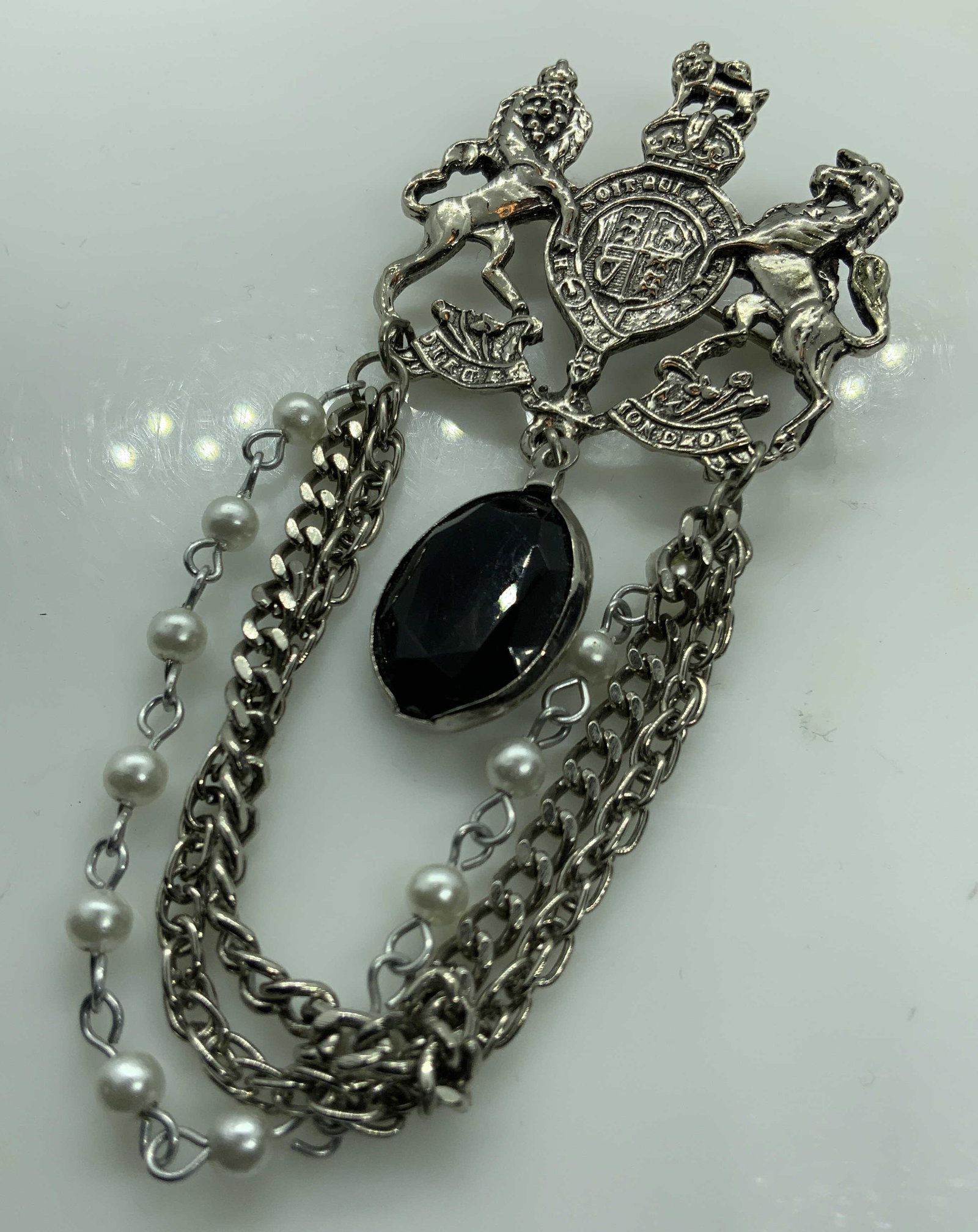 Costume Jewelry Lion Brooch: Costume jewelry, estate jewelry, possibly vintage, pin with shield, lion and unicorn, shield and drop chains, measures app 4 by 2 inches, drop faceted black toned pendant