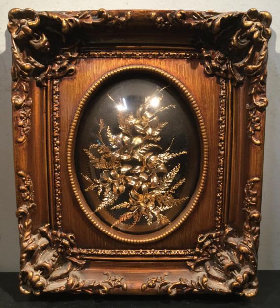 24K Coated Flowers Set in Relief in Frame: Organic flowers coated with 24K gold and set in Relief under convex glass in material composite frame made to appear as wood. Measures approx 14.5 inches in height by 12.75 inches in width by 2.5 inch