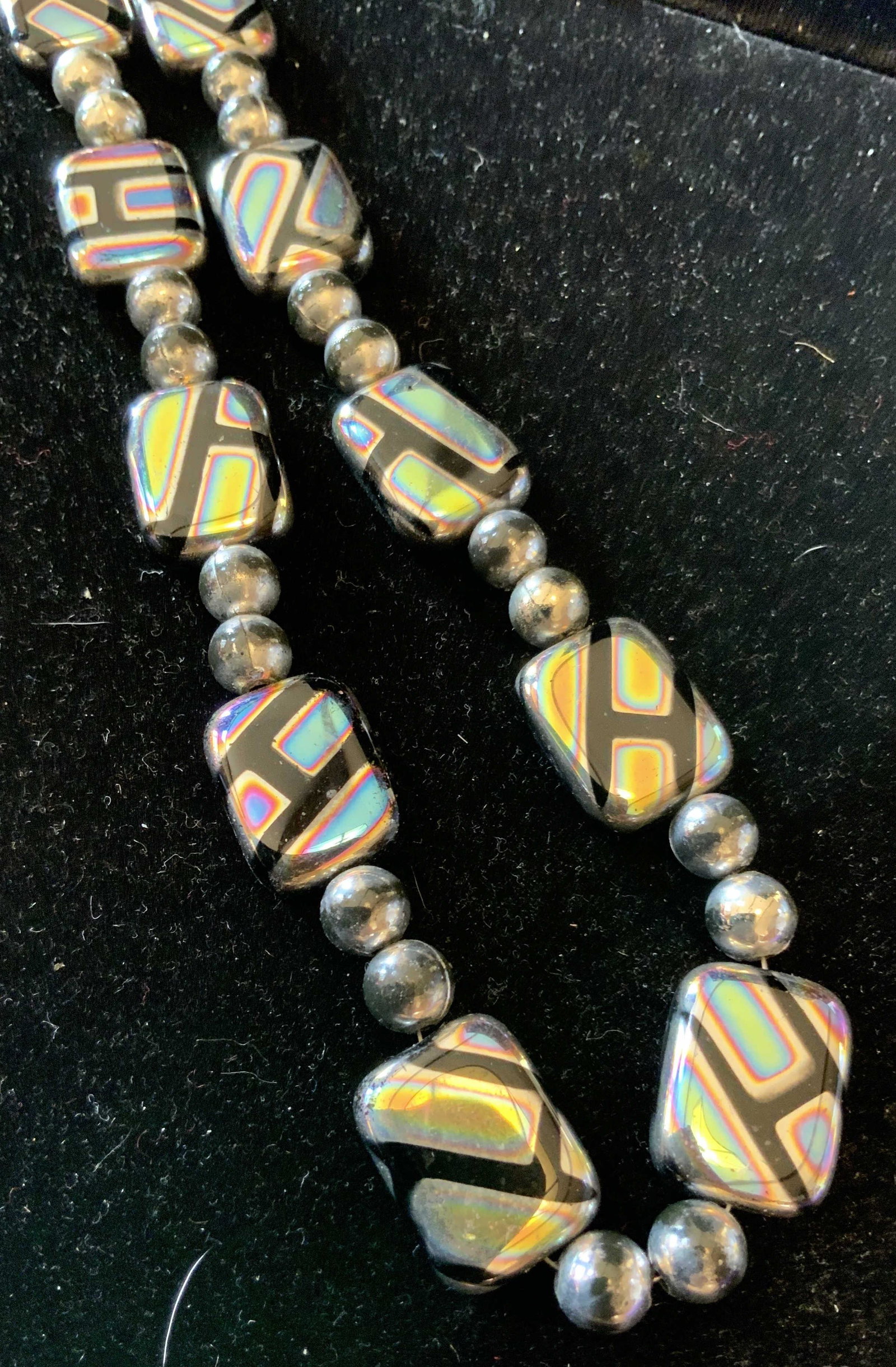 Group 3 Silver Toned Vintage Necklaces: Longest necklace drop measures 19 inches has pendant of rhinestone encrusted orb with silver toned design and chain tassel, one necklace has black toned rhinestone ball pendants, and third has retro s