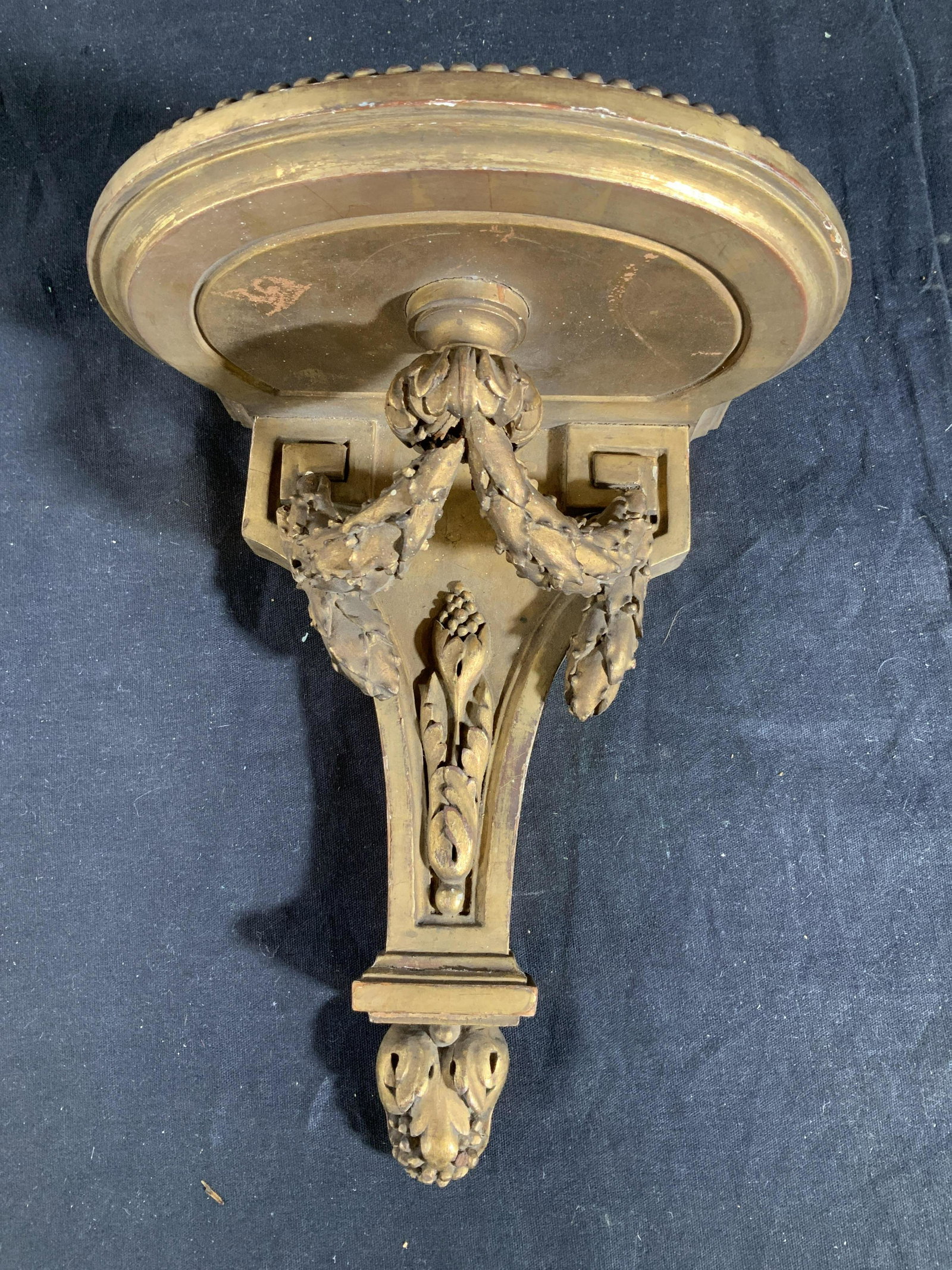 Gold leafed wood Wall Shelf: Wall bracket display shelf, gold leafed carved wood, vintage possibly antique, needs some re attachment measures 10 inches ht width 8 inches depth 6 inches, label on back faded from age, illegible, ho