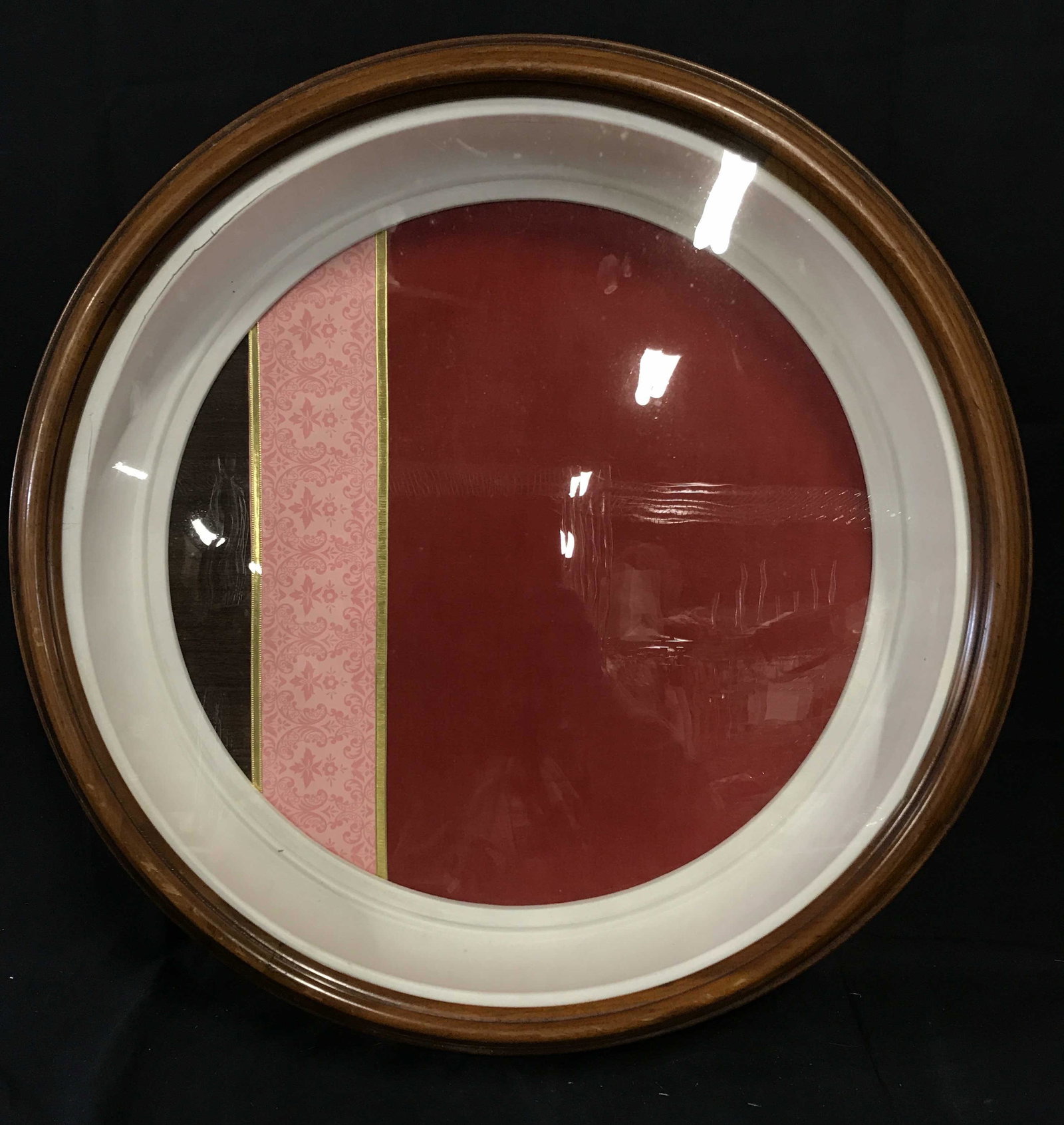 Framed Fabric Shadow Box: Framed Fabric shadow box, wood polished frame, interior of frame painted white, subject fabric elegantly framed the largest plot being a rich berry red bordered by gold ribbon the next being a pink fl