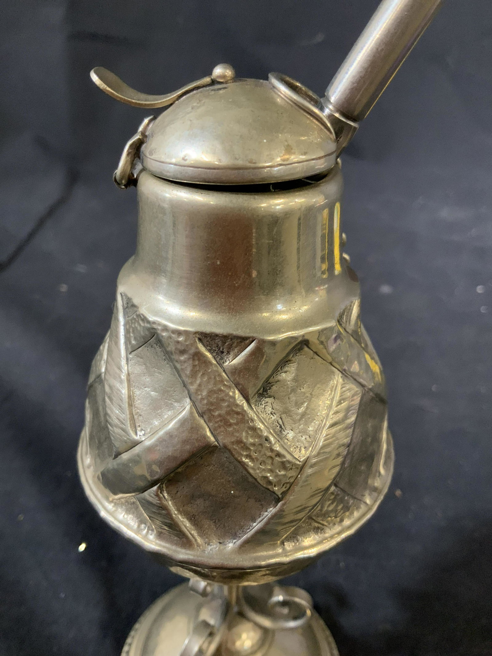 Silver Toned Ceremonial Drinking Vessel: Footed hand wrought vessel with repousee swirl pattern, pedestal base. Hinges lid, attached chain with long stirring instrument attached, ritual ceremonial vessel, possibly tea, possibly hot chocolate