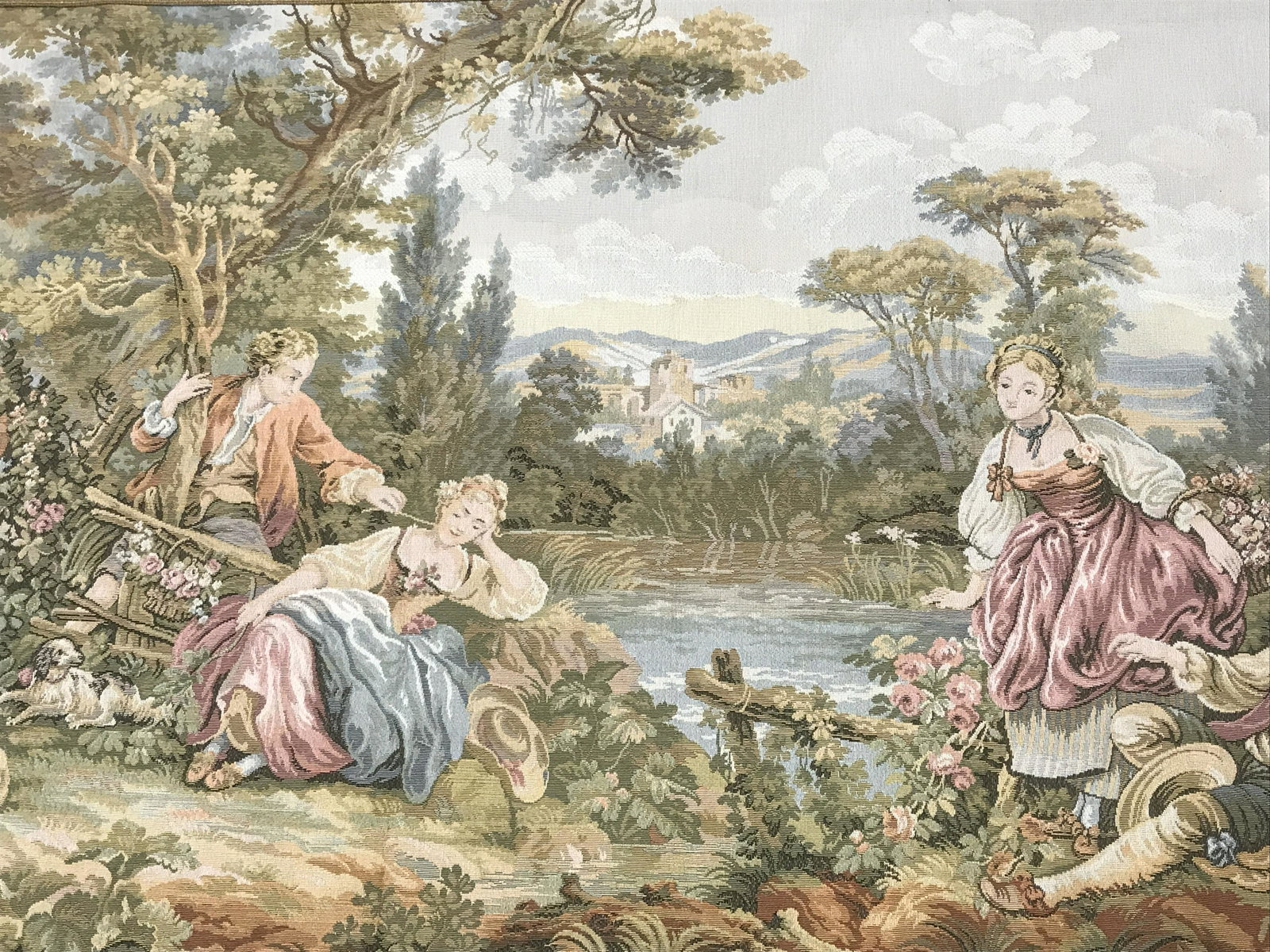 French Petite Point Style Tapestry: Petite point style Tapestry, no apparent signature, label reads made in France, subject rococo style scene of two couples by a river outside an onlooking town with dogs and lambs, fète galante style,