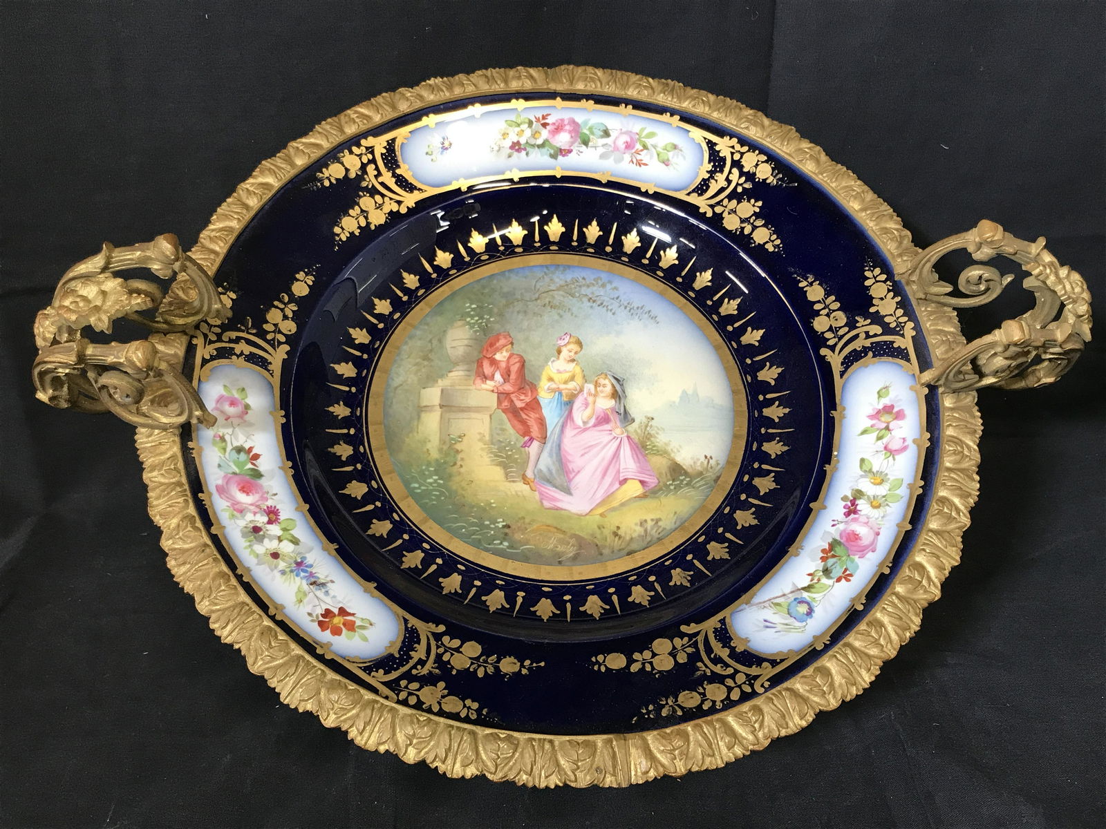Antique Centerpiece Sevres Porcelain: Sevres Porcelain Antique centerpiece ornate painted porcelain bowl with floral bronze handles and footing, bowl painted with gold a cerulean pigment as the base with floral decor, the main scene of th