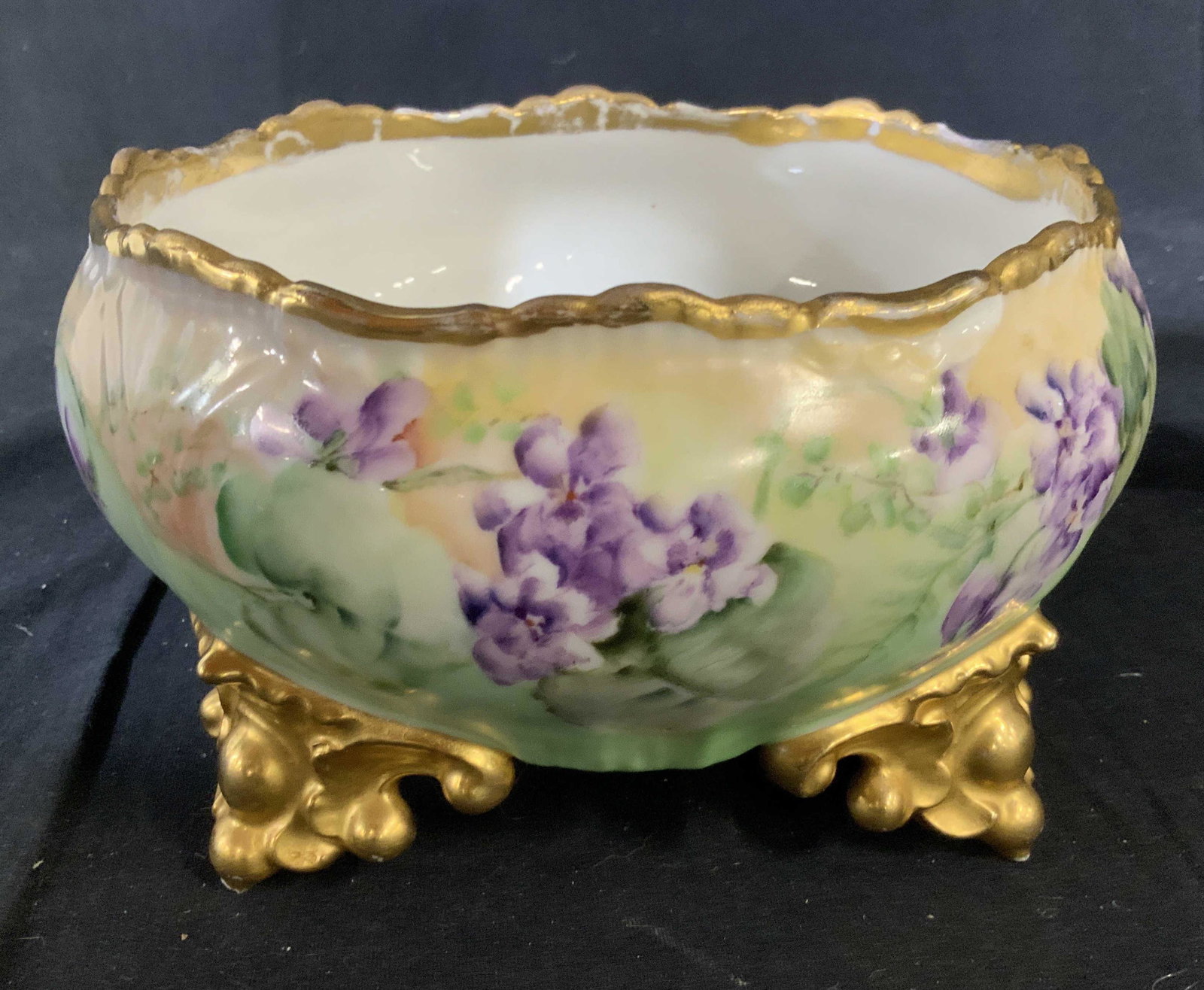 Hand Painted Gilded Limoges Porcelain Bowl: French porcelain, vintage possibly antique Limoges, scrolled gilded feet, hand painted floral design, gold trimmed edges, some minor losses to gold measures ht 4.5 inches diameter app 9 inches, porcel