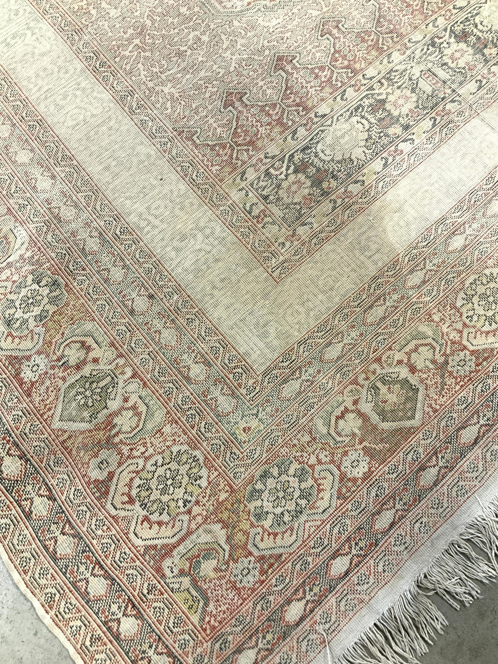 Antique Silk Cotton Prayer Rug: Thin carpet with faded colors of pinks corals, greens and cream, measures 79 by 58 inches, antique prayer rug, carpet, hand made carpet, wear and color fading,