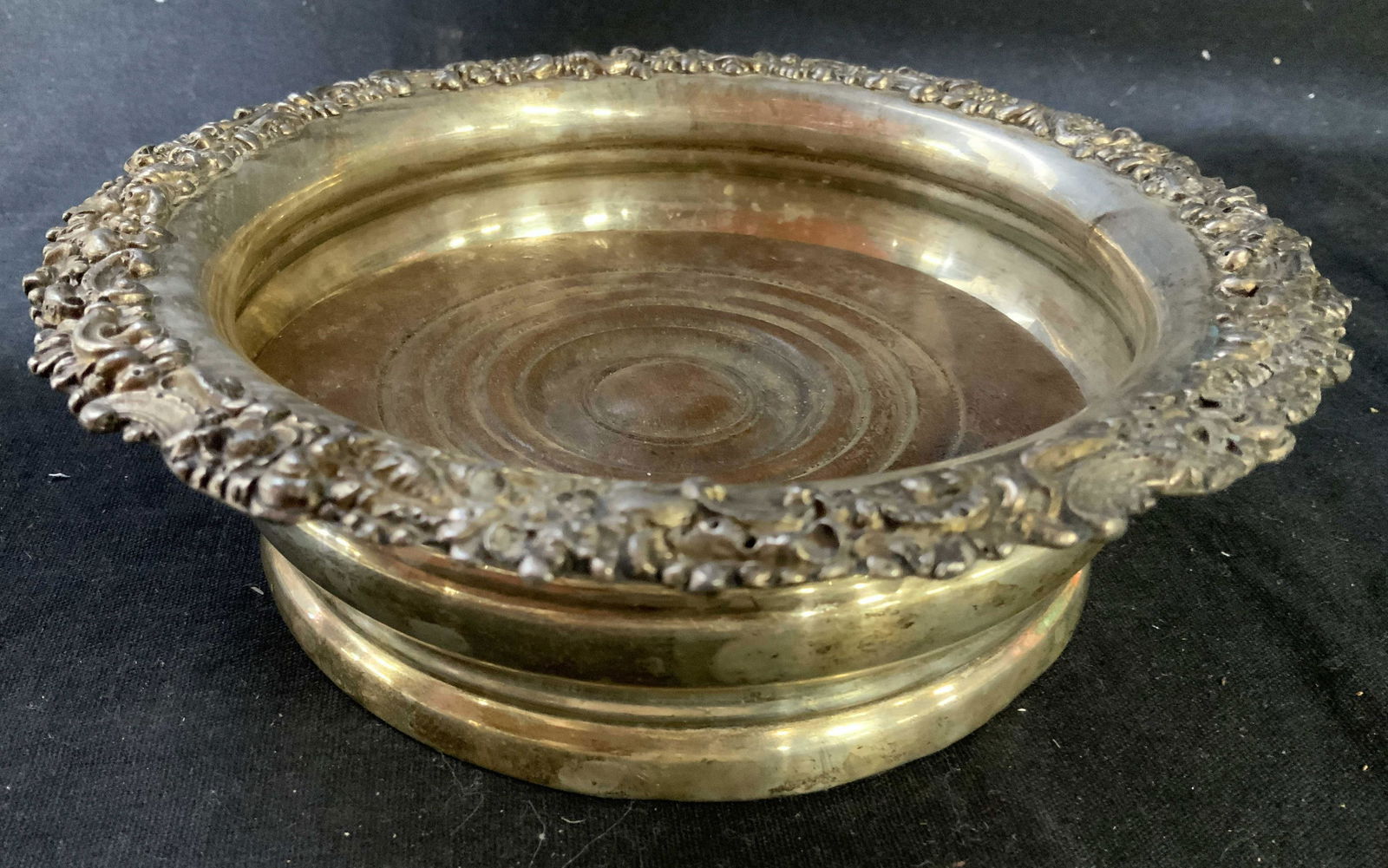 Antique Wood And Silver Plate Bottle Coaster: Possibly english, repousse gallery art nouveau swirls, scrolls, and ringed sides, measures ht 2.5 inches diameter app 6.5 inches, wood ringed center is removable, table ware, wine bottle coaster, coll