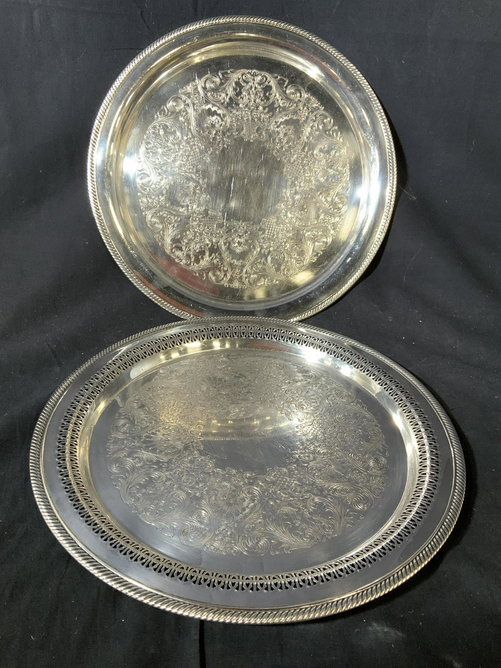 Lot 2 Castleton Silver Plate Serving Trays: Two round serving platters with rope twist trim and etched center design, two in good condition, some minor surface wear, larger measures diameter app 15 inches, one marked William Rogers, one marked 