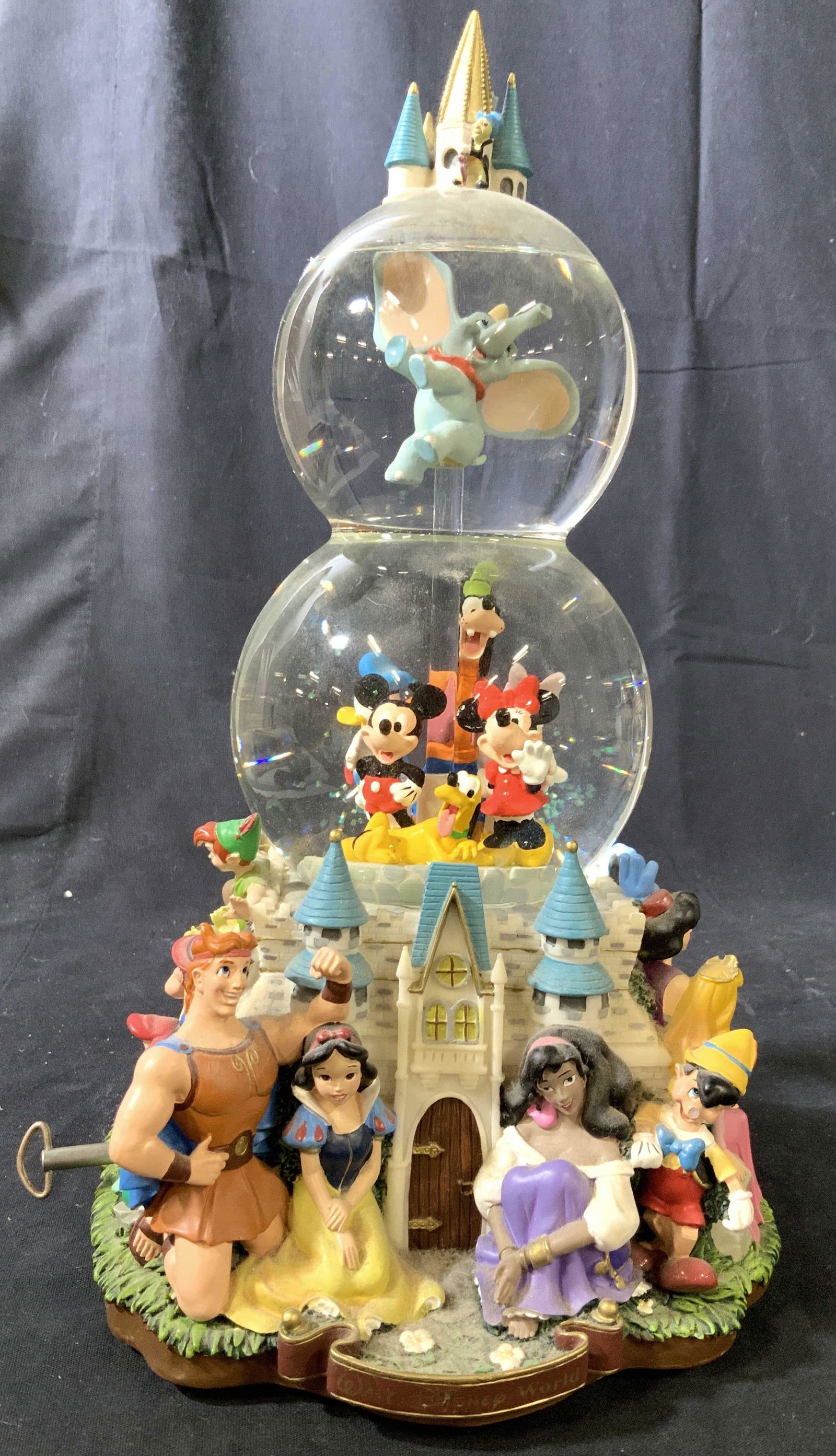 Walt Disney Snow Globe and Music Box: Three tiered shown globe with Figurals of many Disney characters, Mickey Mouse, Minnie Mouse, Snow White, pinnochion, dumbo, Peter Pan, little mermaid and many more, song is Adream is a wish your hear