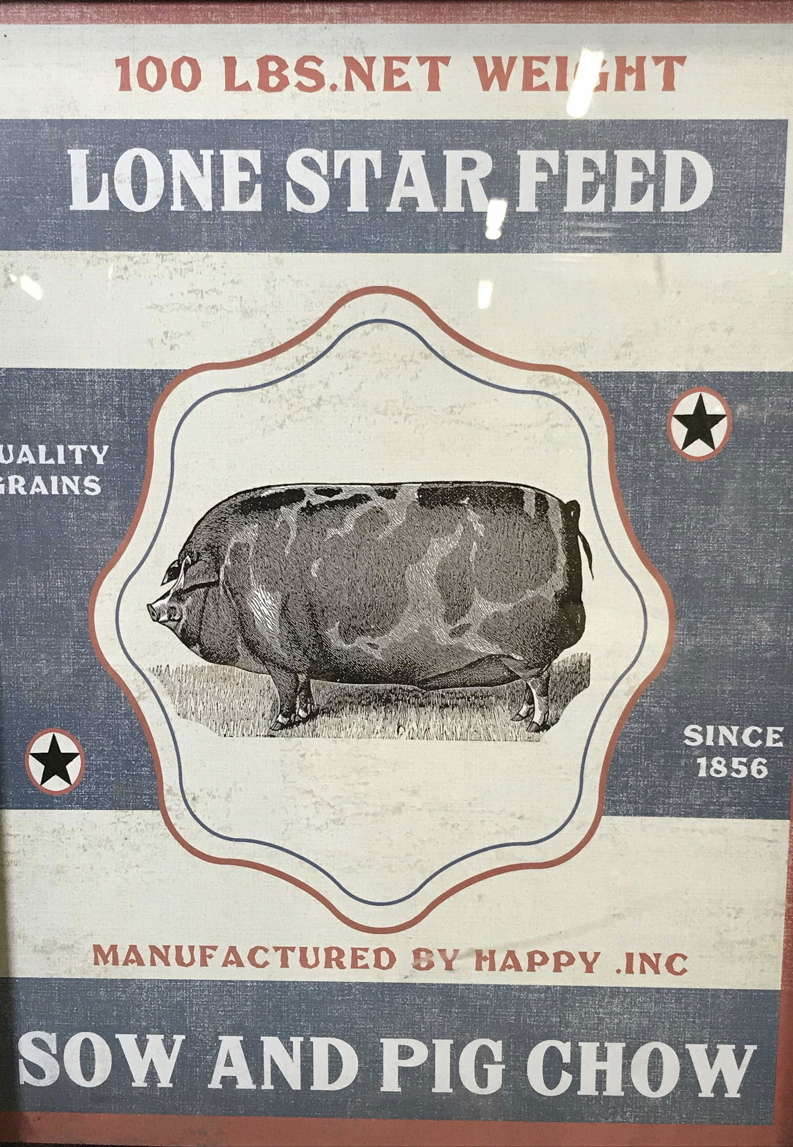 Framed Sow & Pig Chow Advertisement: Framed Advertisement, ad displays text and a black and white pig on a white and blue striped background stars and red border, text on top center section reads ‘100 Lbs Net Weight Lone Star Feed’,
