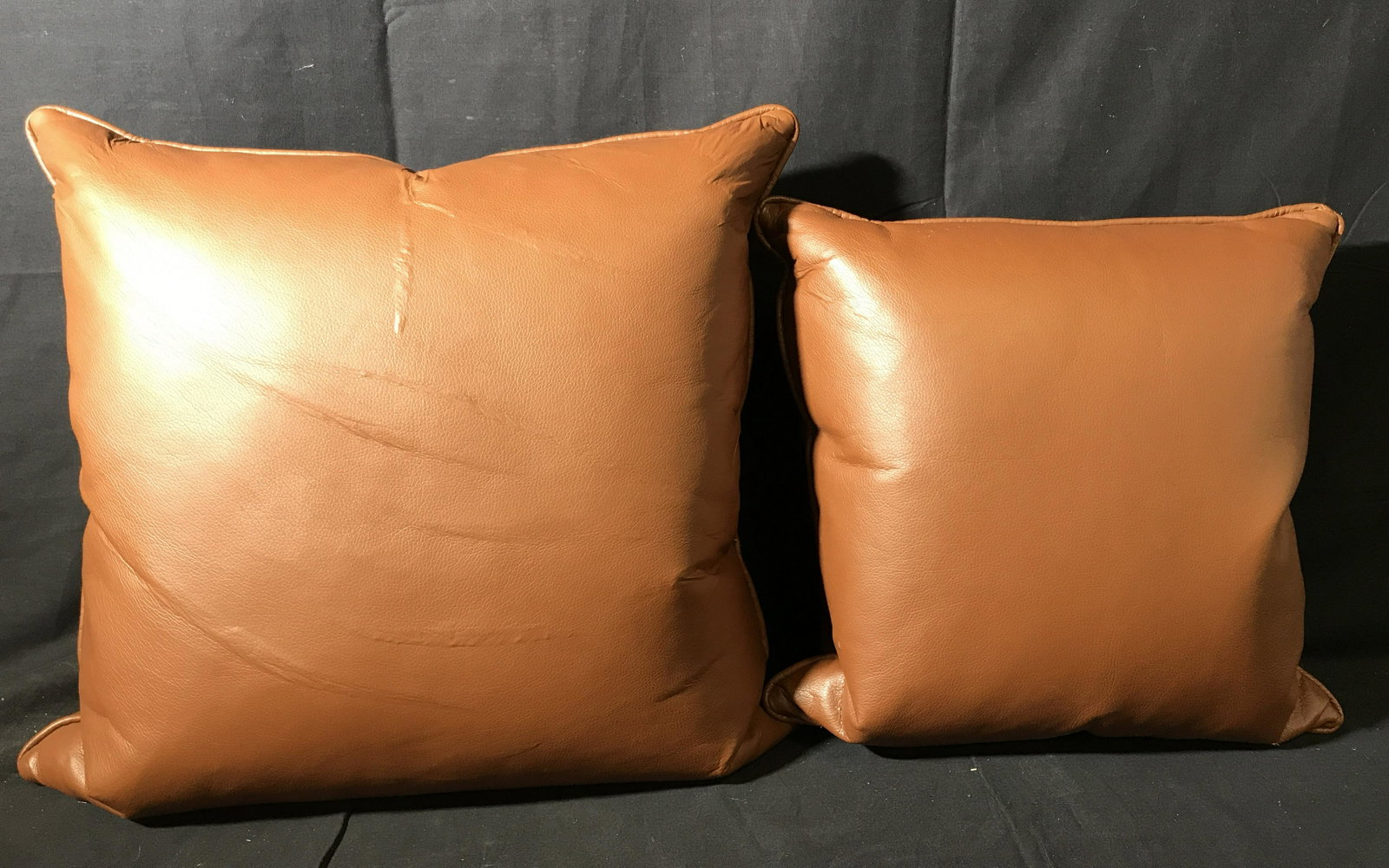 Pair Brown Leather Throw Pillows: Pair Brown Leather throw pillows, some wrinkles and small sips to leather, zipper located in the side of each, larger one measures approximately 17 inches tall, smaller one measures approximately 16 i