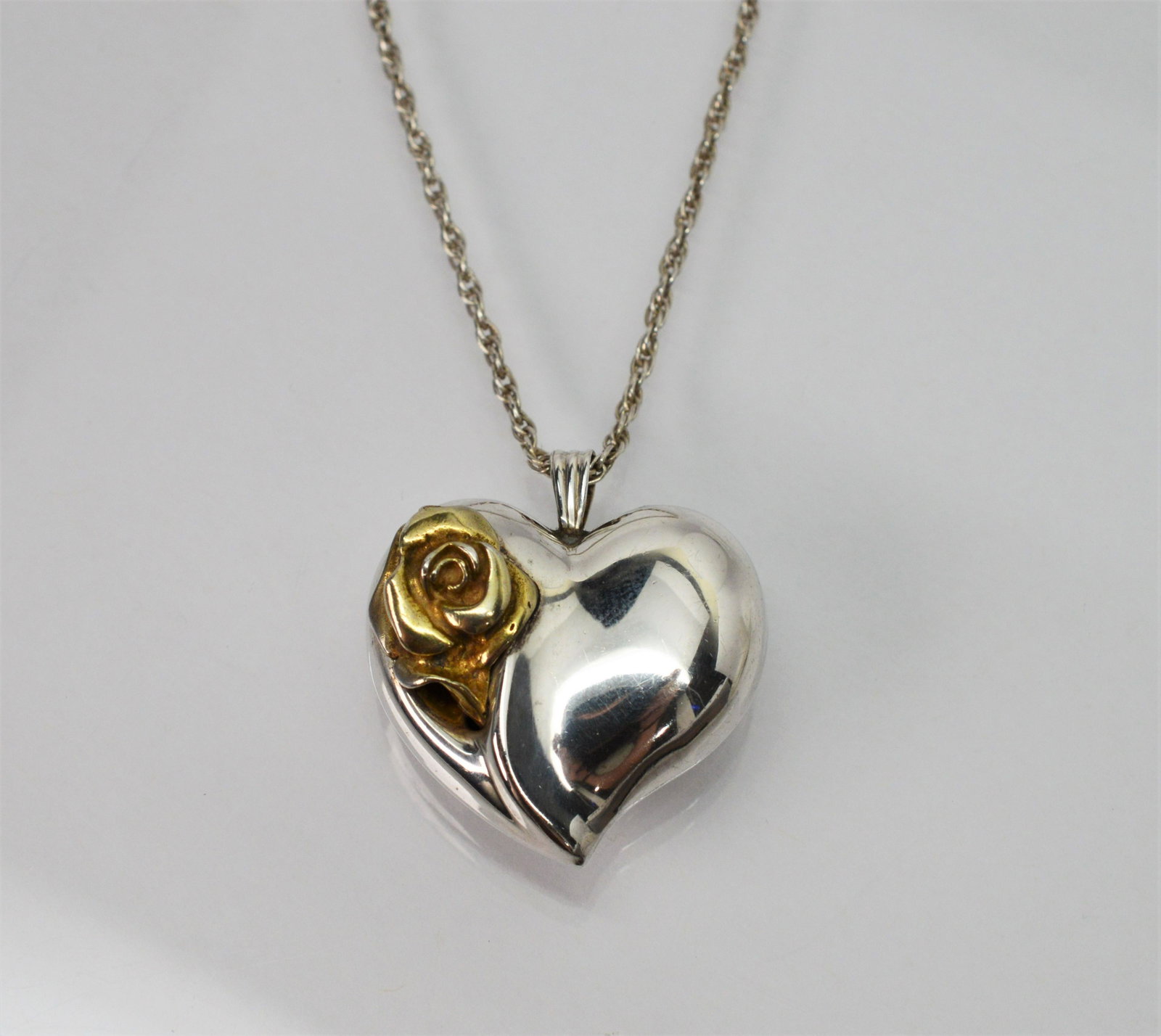 Vintage Gorham Sterling Silver Heart Necklace: Vintage Gorham Sterling Silver Heart Pendant Necklace. 24 in length. Vintage piece by Gorham Co., in .925 sterling silver, a romantic heart pendant accented with a gold tone rose. Measures approximate