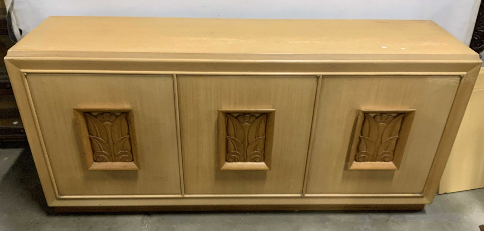 Mid Century Modern Light Wood Credenza: Console table, side board, credenza, mid century modern, vintage console table, features three spring door opening cabinet doors, each with ups set carved wood in slightly darker tone, scroll leaf mot
