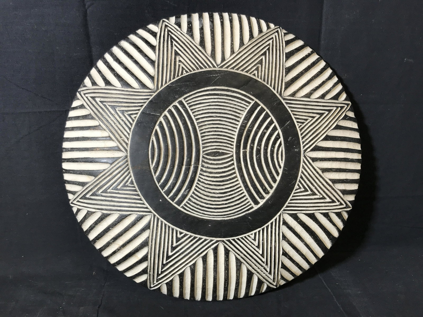 Ceremonial Zulu Shield: Ceremonial Zulu Shield, origins can be found in South Africa, wooden shield with black and white paint with a sun pattern carved into the front, handle carved into the back, diameter approximately 22 