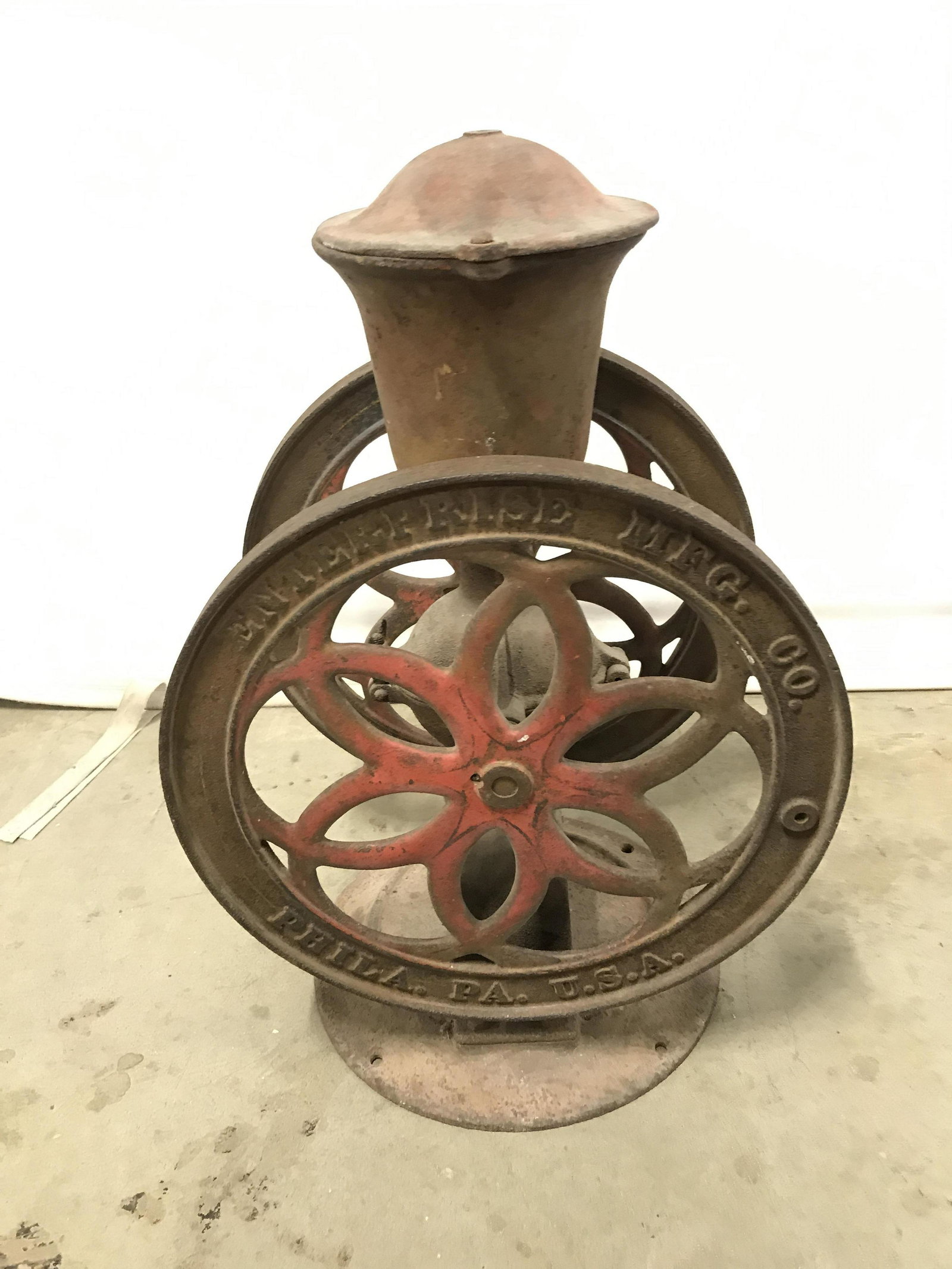 Antique ENTERPRISE MFG CO Cast Iron Coffee Grinder: This is an antique Coffee grinder, manufactured by ENTERPRISE MFG CO. The piece is crafted from cast iron and is hand operated. The wheels on each side of the grinder read, ENTERPRISE MFG CO. PHILA. P