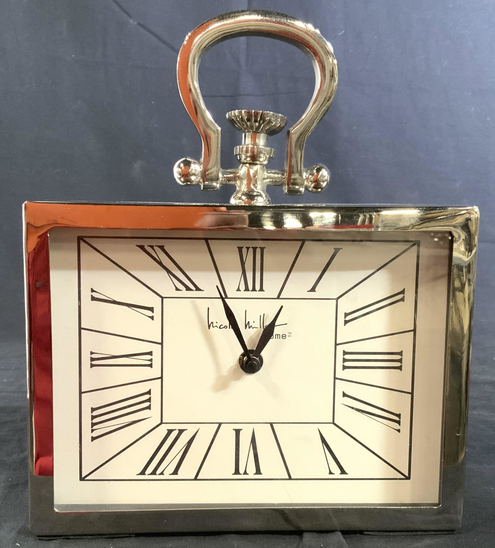 Chunky Chrome Style Nicole Miller Clock: Decorative desk top accessory, chunky style chrome style with carry handle, clock, label reads Nicole Miller, measures htb10 inches, width 8 inches, depth 2 inches, decorative object, Nicole Miller cl