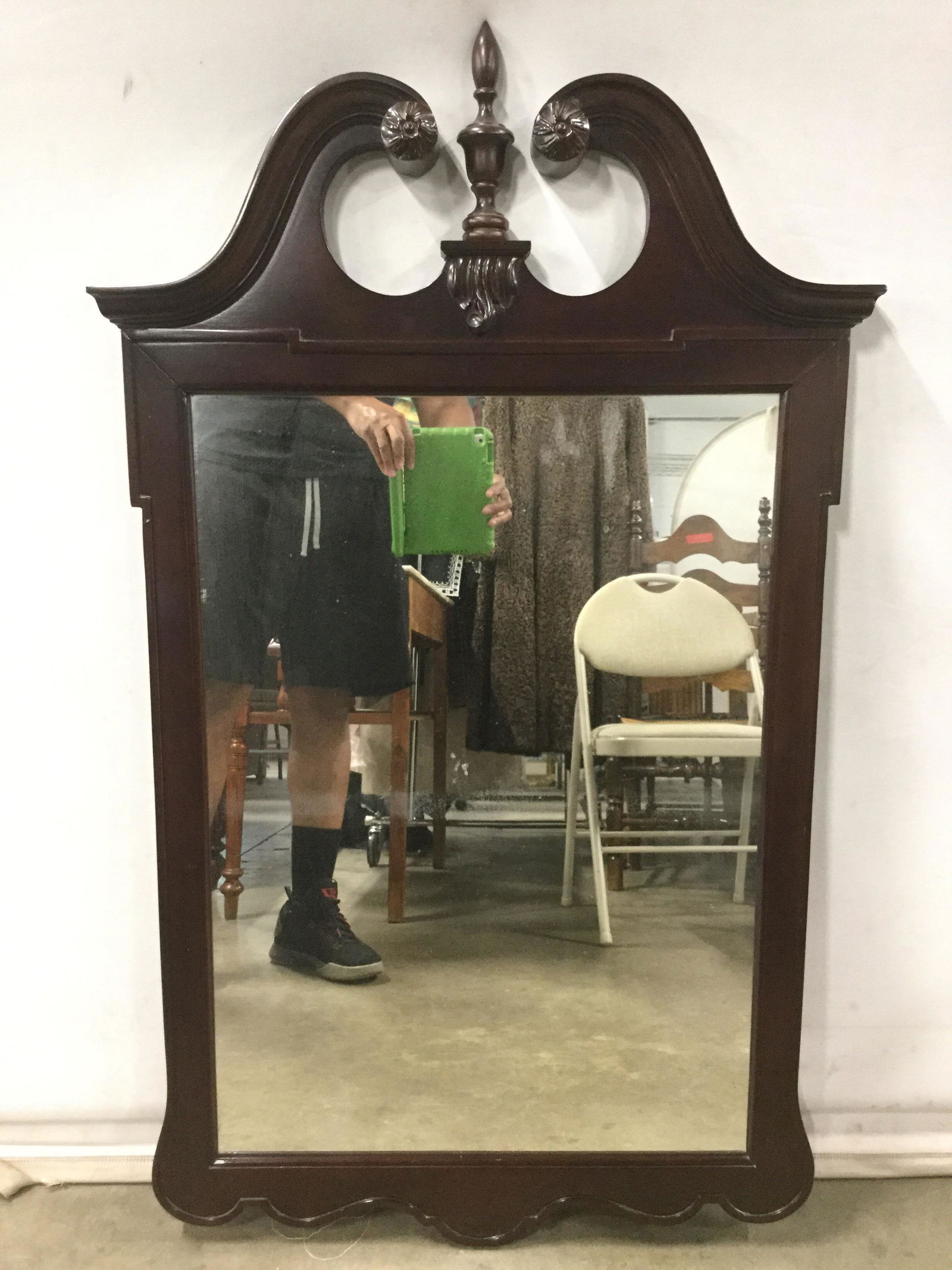 Vintage Carved Wood Frame wall Mirror: Mirror is wooden. Piece is vintage. Contains carved wooden detail including s curve, floral and finial detail at top. Mirror has wire for hanging on backside. Piece measures approximately 43 inches ta