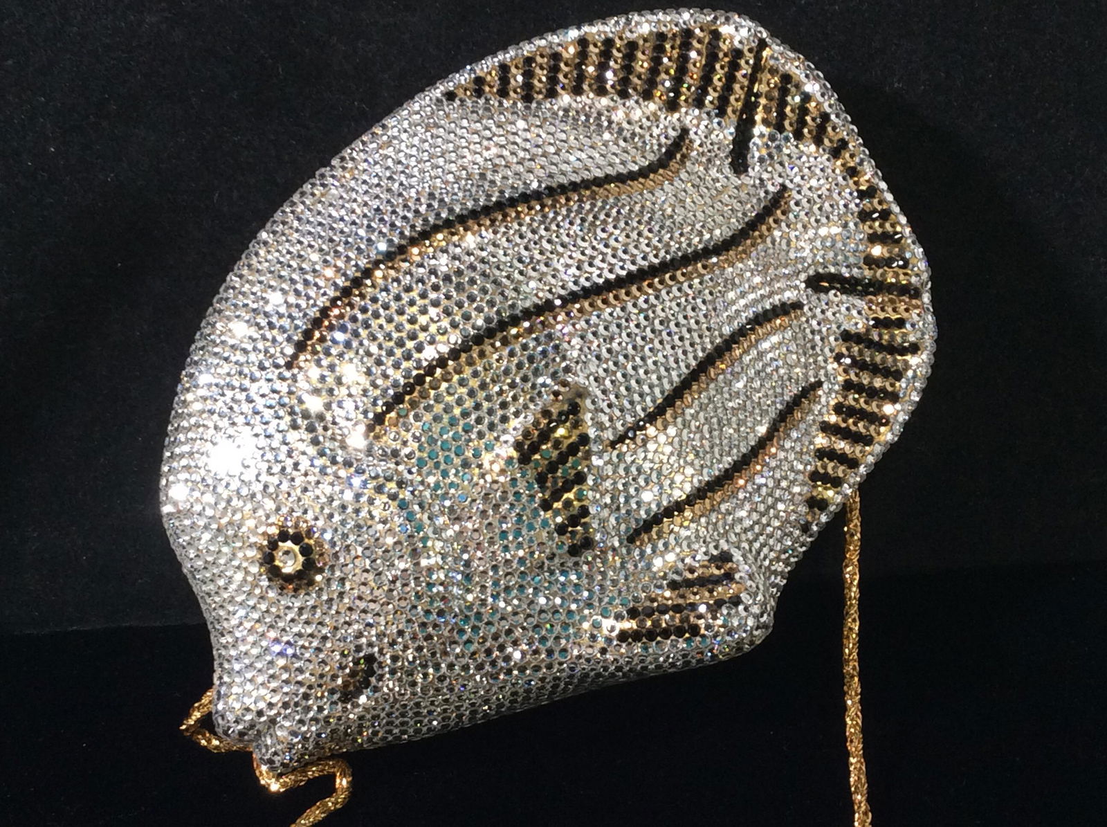 Hard Case Crystal Fish Shoulder Bag: In The Style Of Judith Leiber. Interior black felt lined. Sparkling clear crystal clutch, tuck in gold tone shoulder chain, drop length 20 in. Bag accented with black and gold crystals for fins and sc