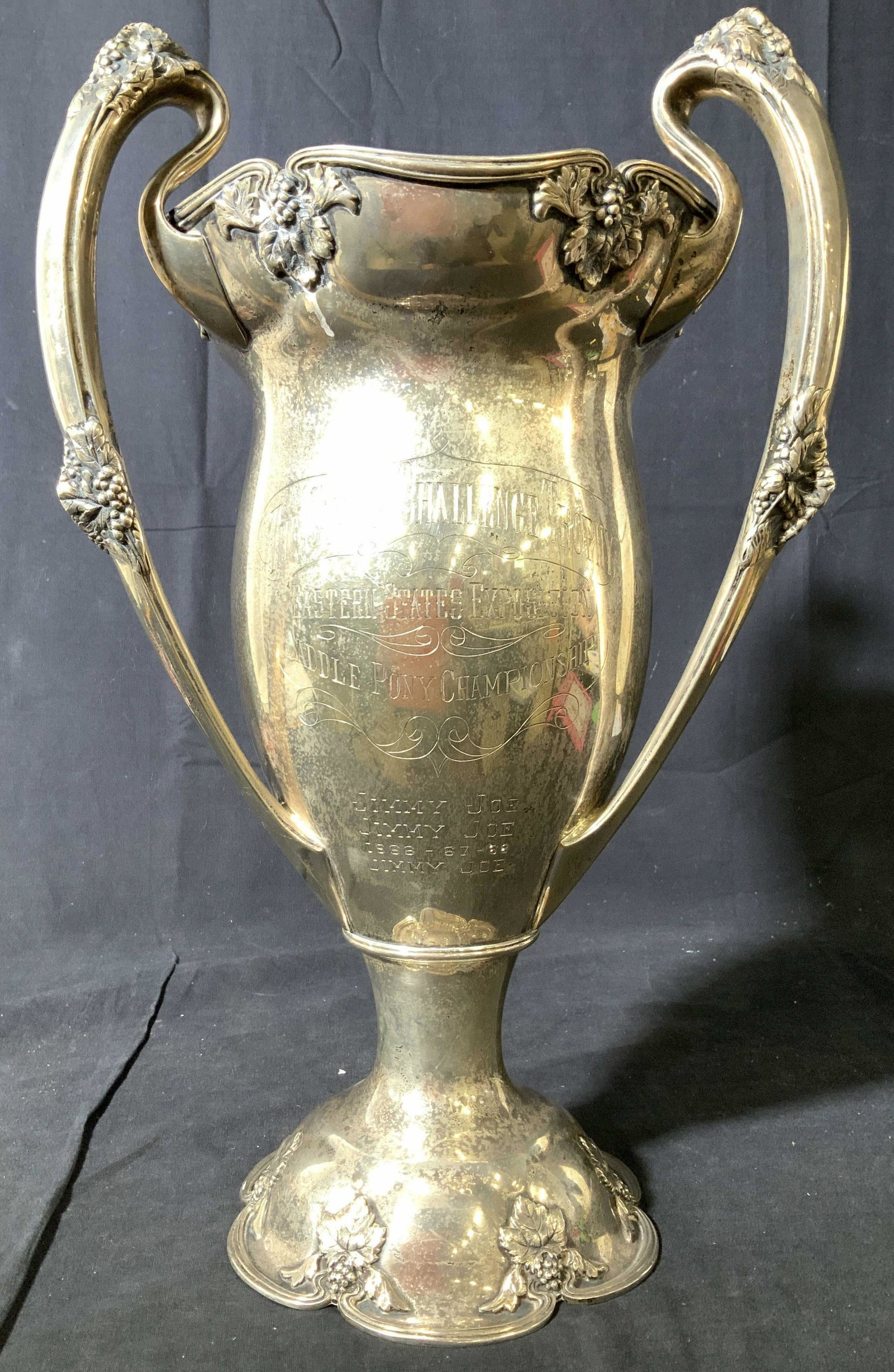 Large Sterling Silver Trophy Urn, 83.02 TOZ: Art nouveau style trophy urn, marked underside for Sterling, urn measures ht 17 inches, width 11 inches, weight 83.02 ounces, urn has scalloped pedestal base with leaf vines scroll work in relief, flu