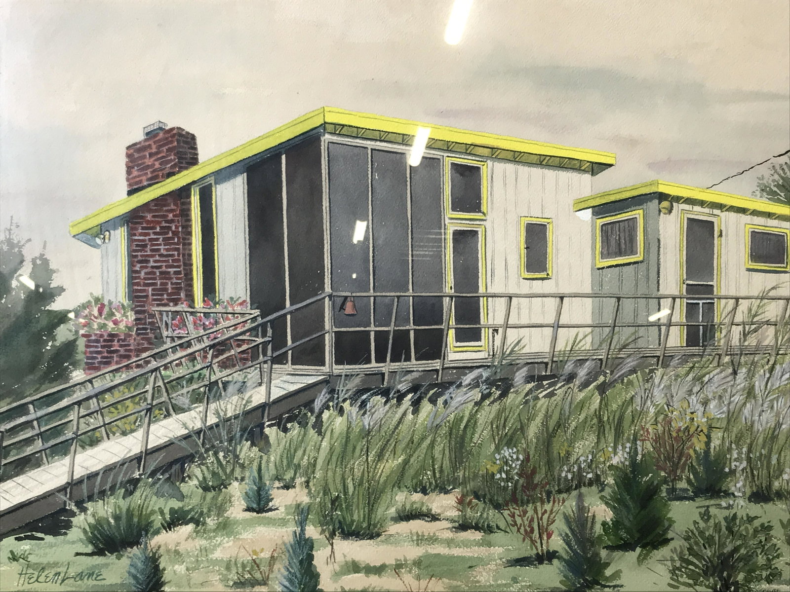 Signed Watercolor on Canvas Paper Helen Lane: Signed watercolor on canvas paper, subject a modern home with yellow roofing and lush greenery surrounding it, brown burlap matting, wooden frame with gold metal lining the edges, measures 22.25 inche