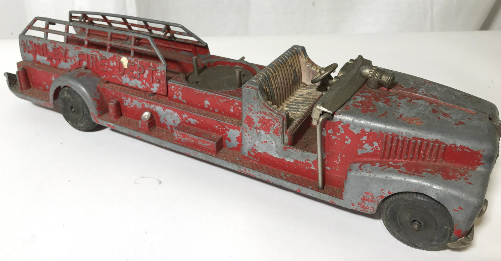Vintage HUBLEY KIDDIE TOY Die-cast Fire Truck: The piece measures approx 3.25 inches H, 4.25 inches W, and 16 inches long. The piece is crafted from die-cast Metal. The piece is absent it’s windshield and ladder. The wear present is consistent w