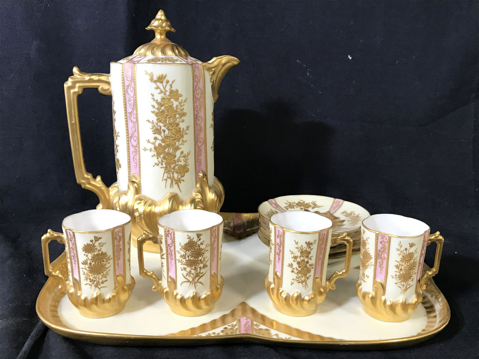 Lot 10 Fine French Porcelain Demitasse Set: Lot includes 1 tray, 1 espresso pot, 4 cups & 4 saucers. Each piece is vintage possibly antique. Set has intricate ornate gold toned detail with pink toned accents. Tray measures approximately 13 inch