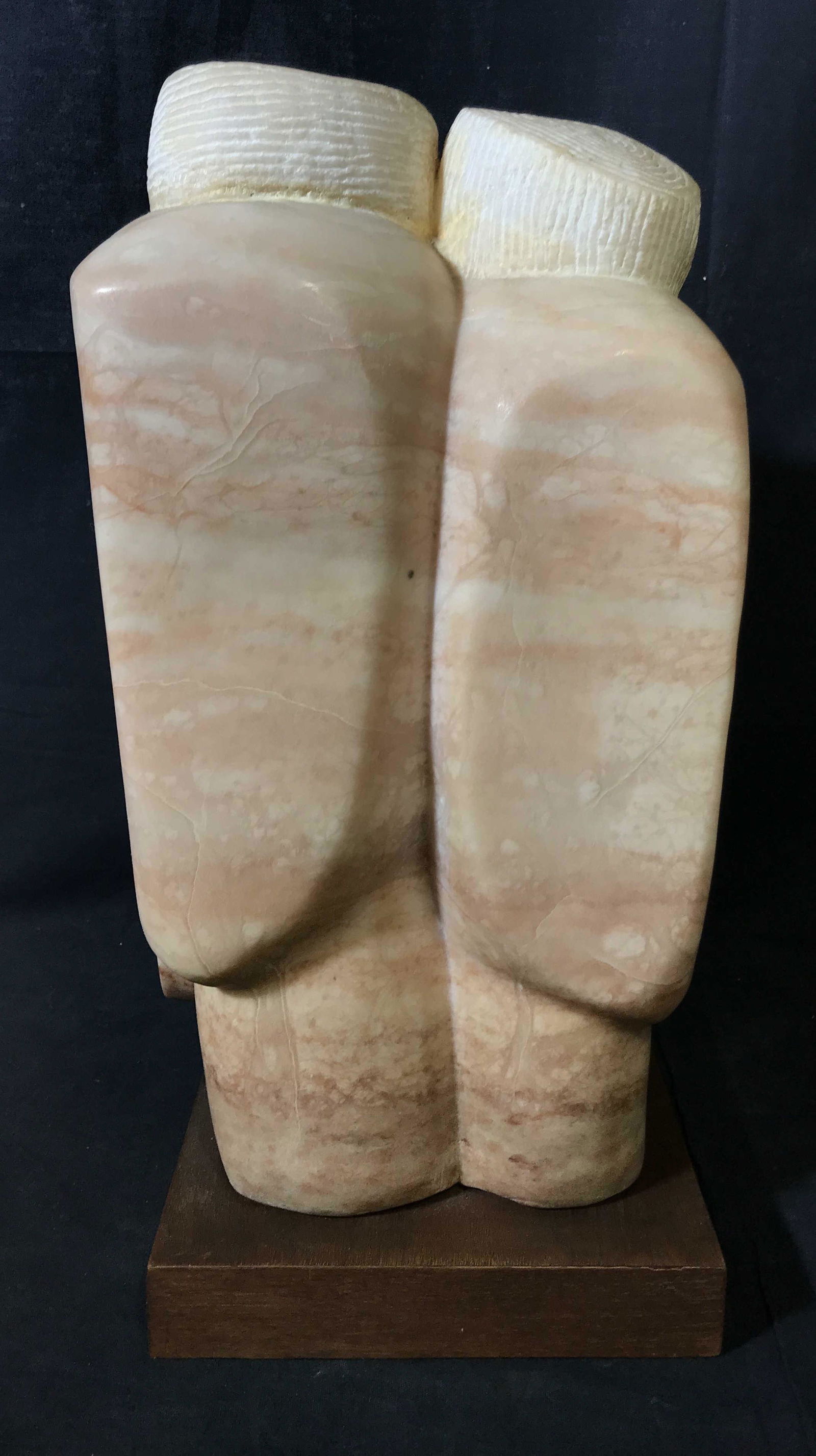 Polished Pink Marble Abstract Sculpture: Polished White variegated Marble statue with wooden base, signature lower right side reads Helga, subject an abstract sculpt of possibly two figures, pink and peach variegated marble with white veinin