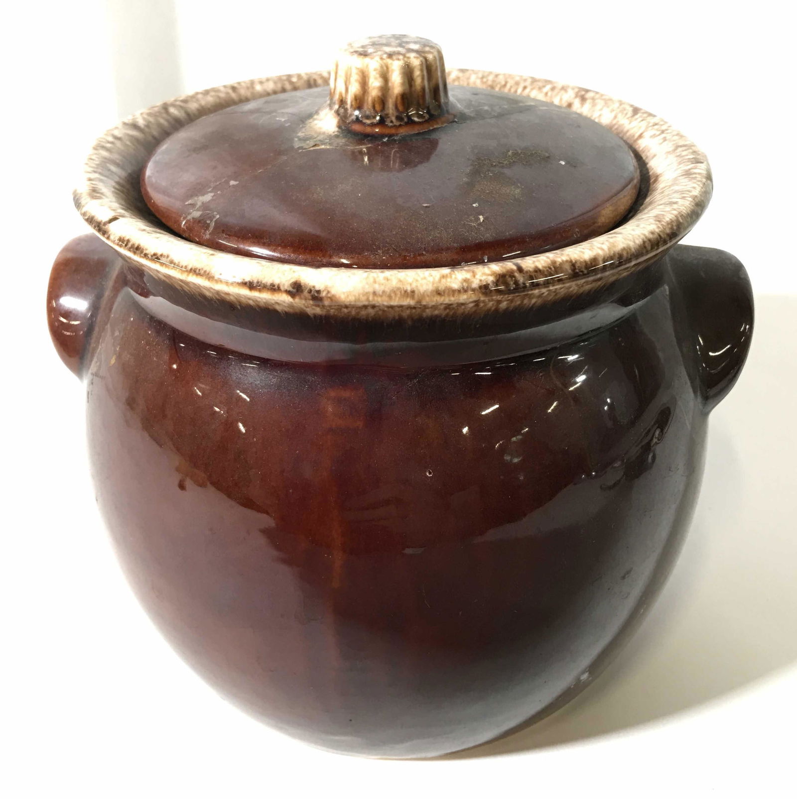 HULL Glazed Ceramic Cookie Jar: This is a glazed ceramic cookie jar. The handle on the lid resembles the stem of a squash or pumpkin, the underside of the jar reads:HULL, OVEN PROOF. The piece measures approx 7 inches H, and 7 inche