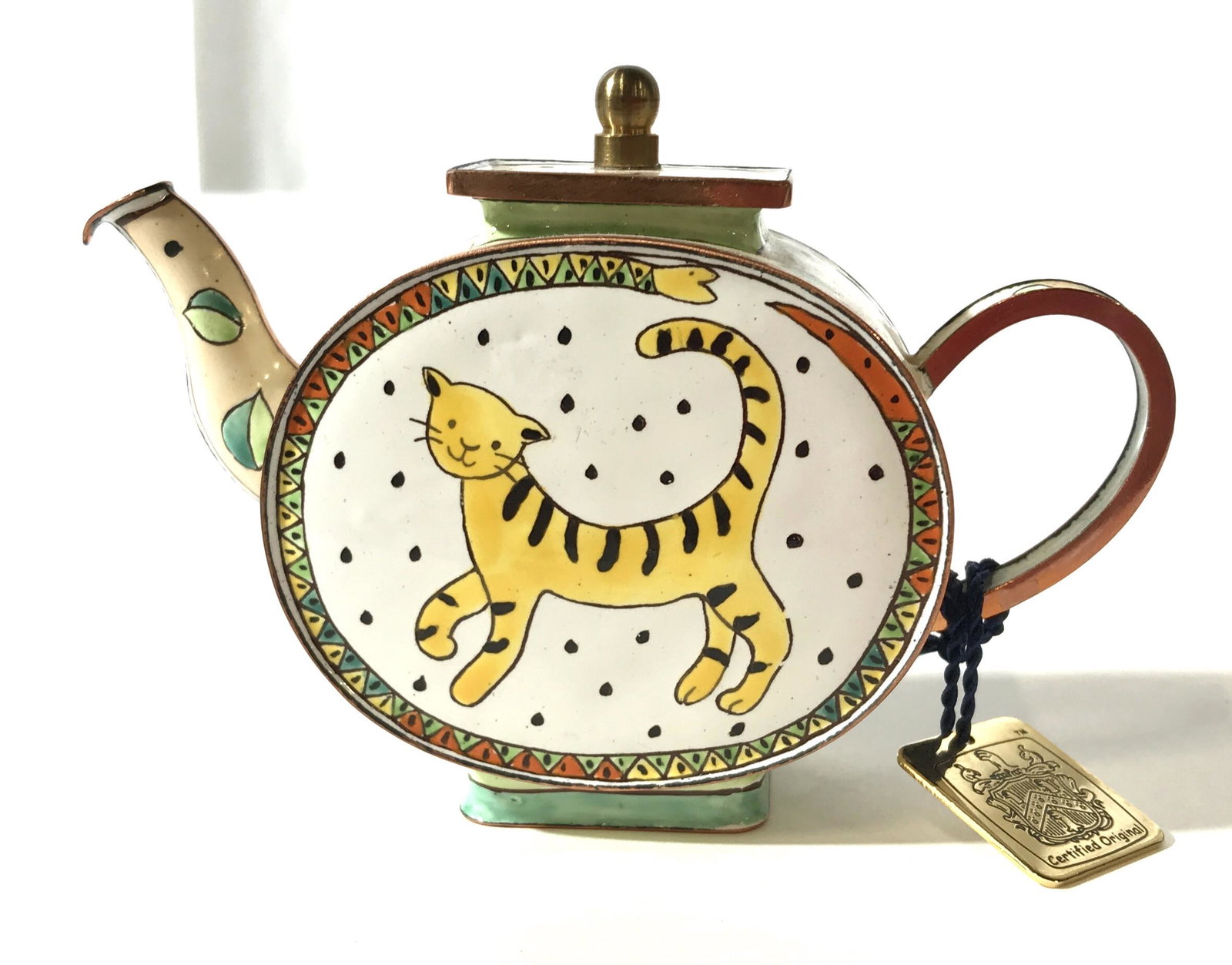 Collectible CHARLOTTE DI VITA Tea Kettle, LONDON: This is a collectible, hand painted tea kettle. The kettle depicts a Stylized tiger on a polka dotted background. The piece appears to be crafted from brass and enamel. The kettle comes with an orange