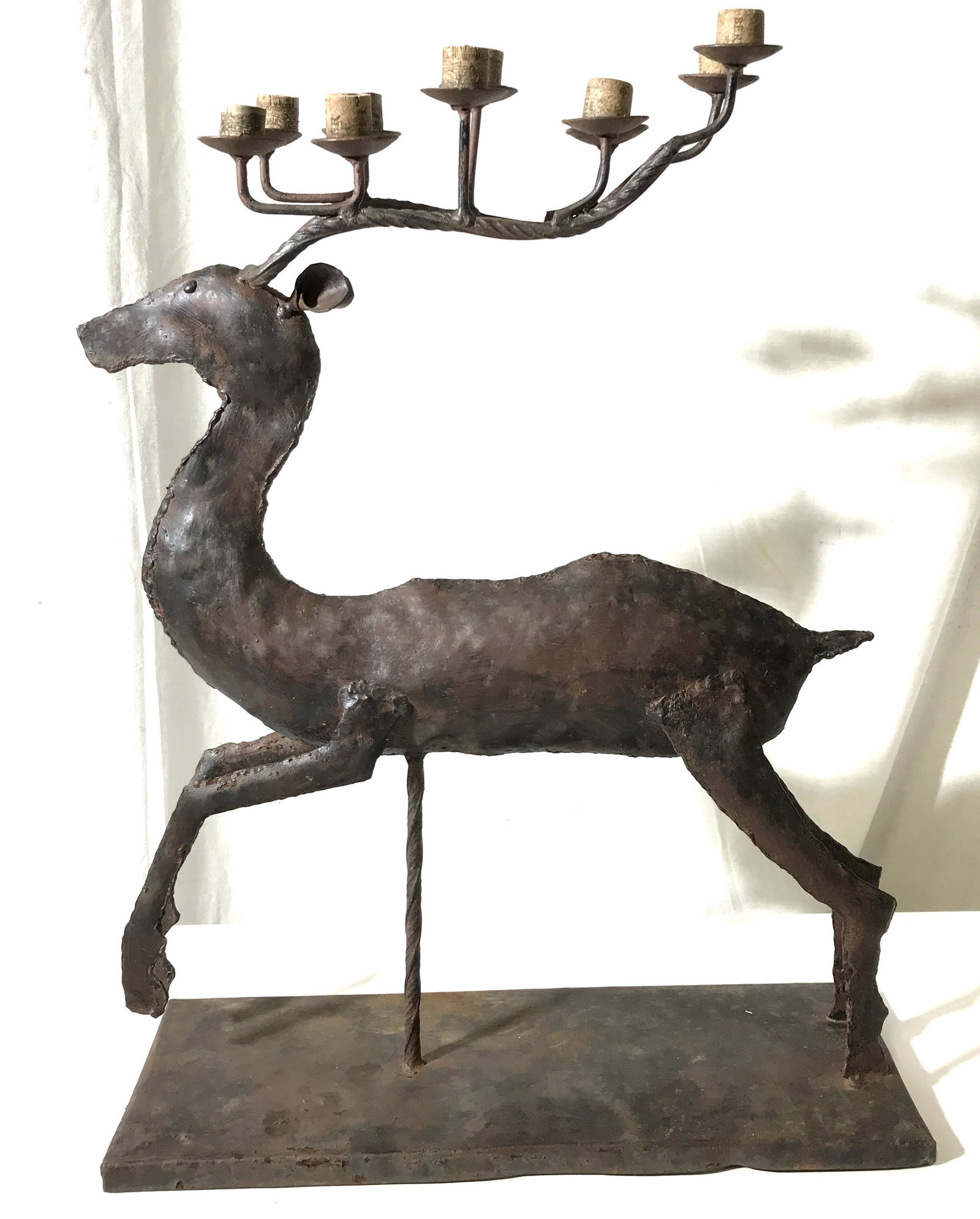 Vintage Cast Iron Reindeer Candelabra: This piece is a candelabra fashioned to resemble a reindeer. The piece can hold up to ten candles, on its antlers. The piece measures approx 24 inches H and 18 inches W. There is wear present on the p