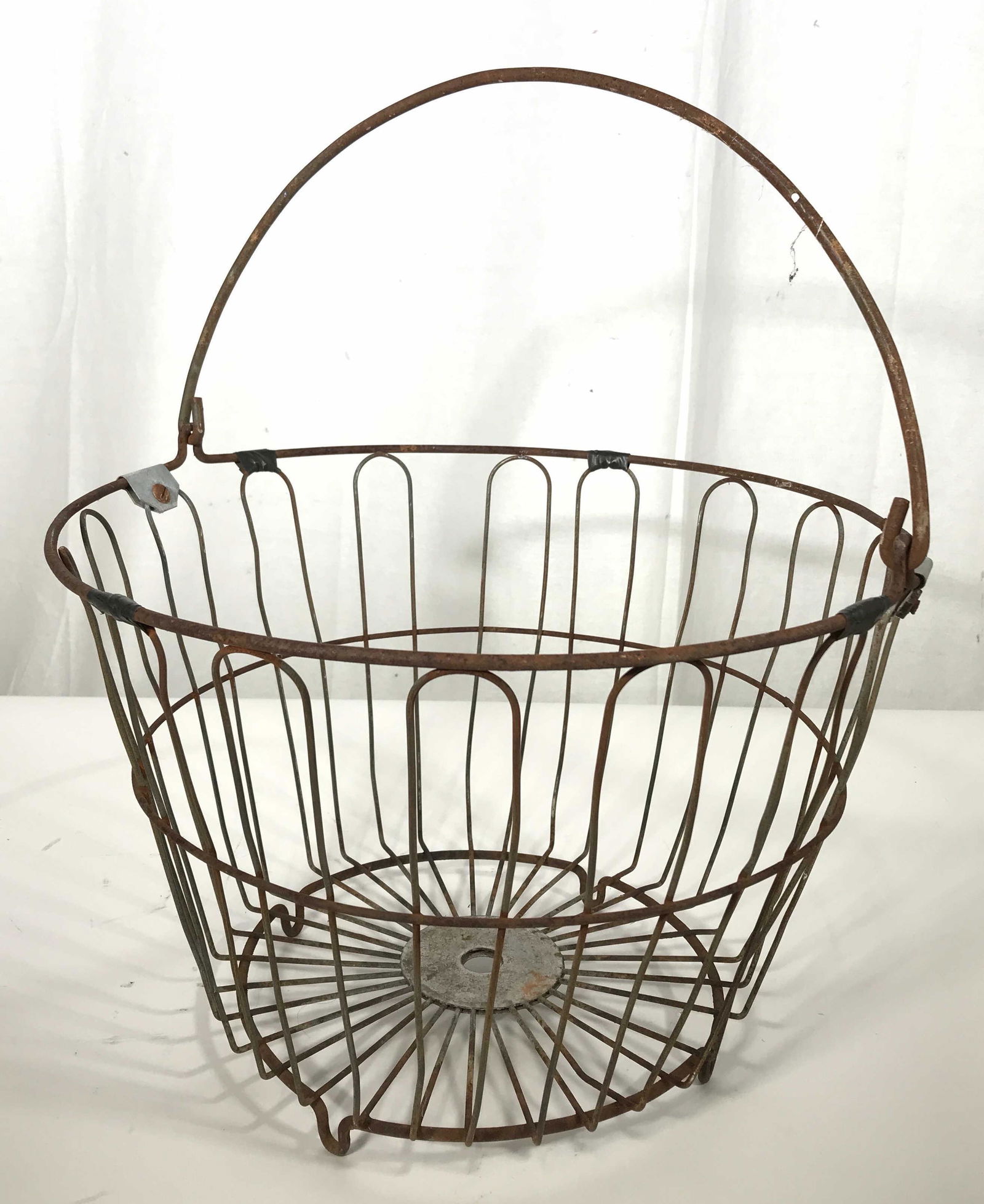 Vintage Cast Iron Basket: This piece measures approx 16.75 inches H and 14 inches in diameter. The basket is constructed from cast iron. There is wear present on the basket consistent with age and exposure. Wire basket, outdoo