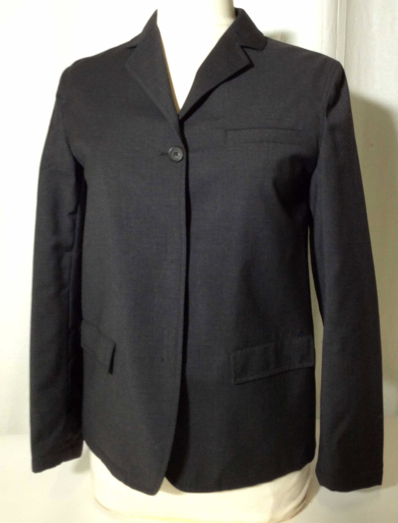 PRADA Classic Wool Blazer, Italy: International size 38. USA size small. Dark grey, slightly padded, 1 center button and Velcro closure. Label reads PRADA MILANO MADE IN ITALY. Other label reads 100% wool, 100% nylon lining. 25 in. Lo