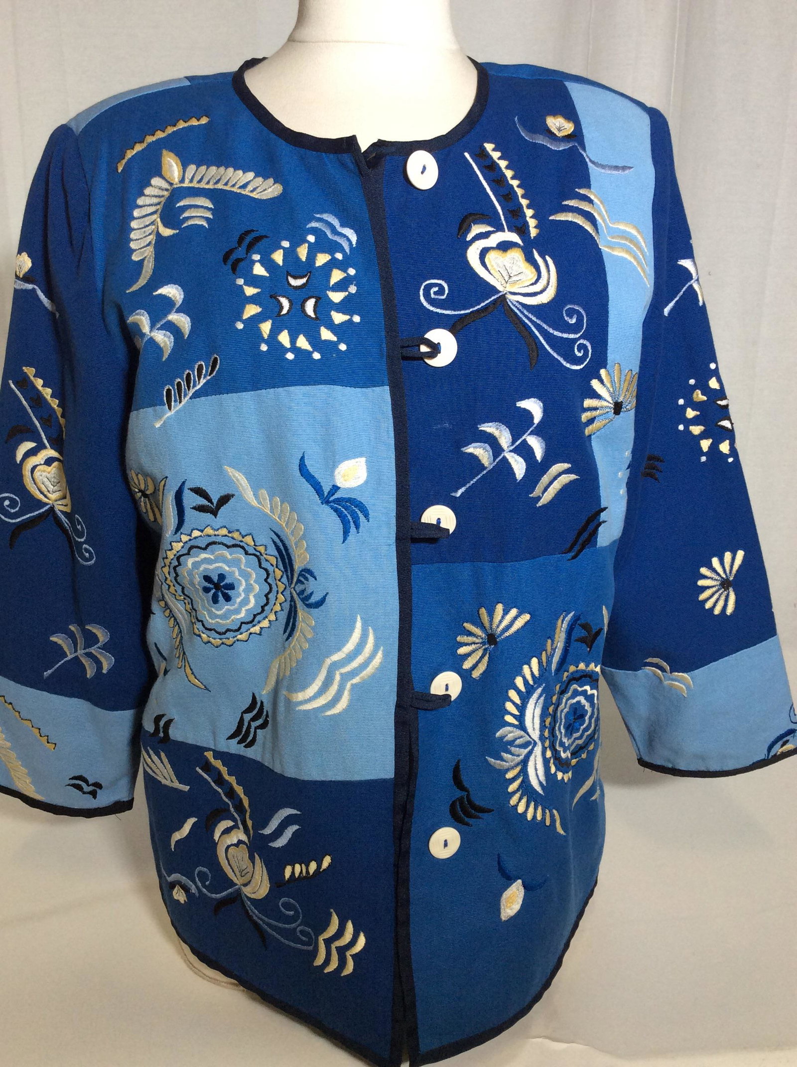 Indigo Moon Cotton Embroidered Blazer Jacket: Size M, boxy Shape, Interior Lined, Buttons with loops, color blocking of light blue, Jean blue and medium blue. Appliqué Embroidery. 26 in. Long, sewn in shoulder pads. Casual wear, ladies jacket bl