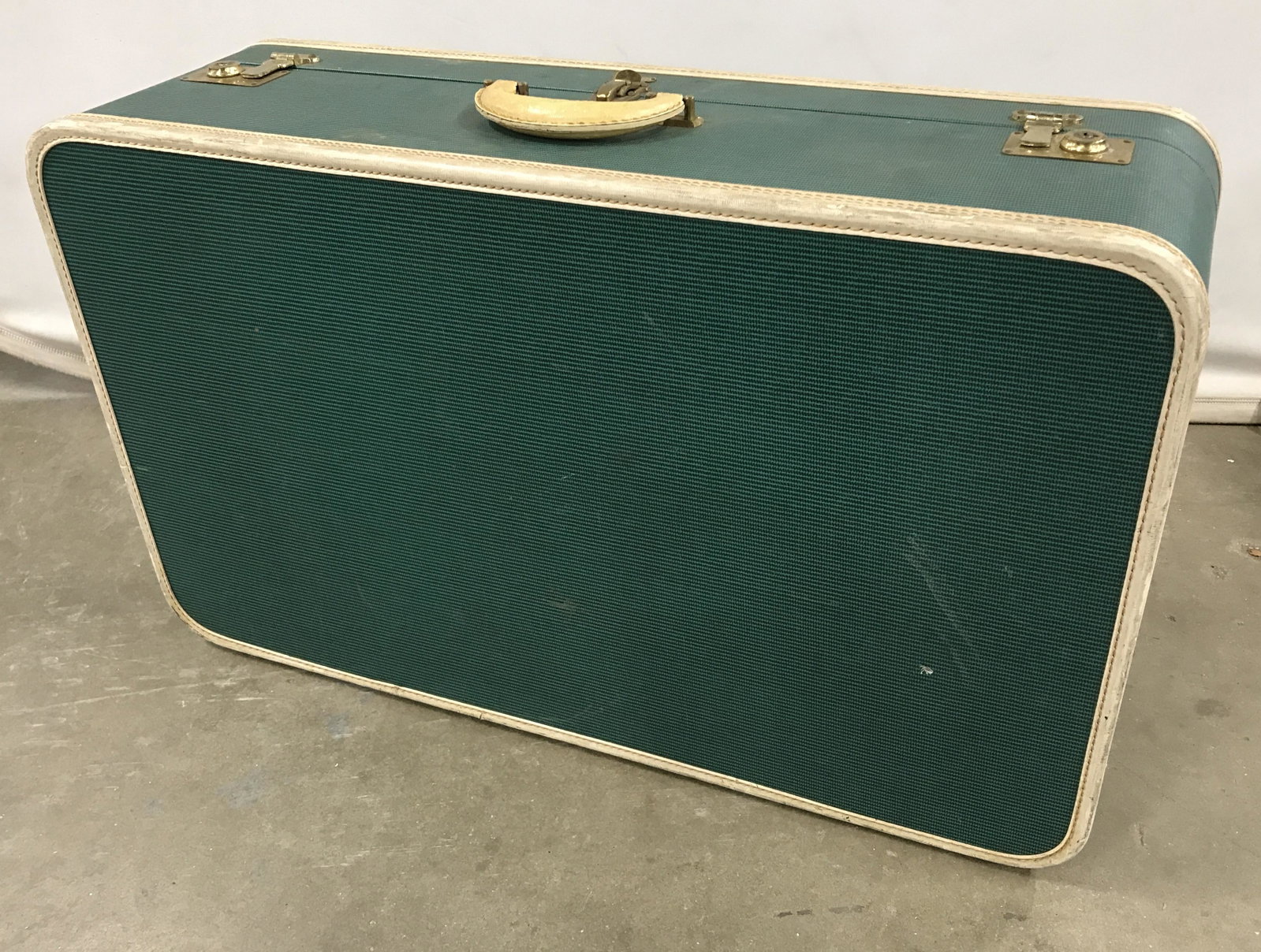 Vintage MENDEL Suit Case: The suitcase measures approx 17.5 inches H, 28 inches W, and 8.75 inches Deep. The case was manufactured by MENDEL. The tops can be secured through the use or brass clasps. The piece is teal toned wit