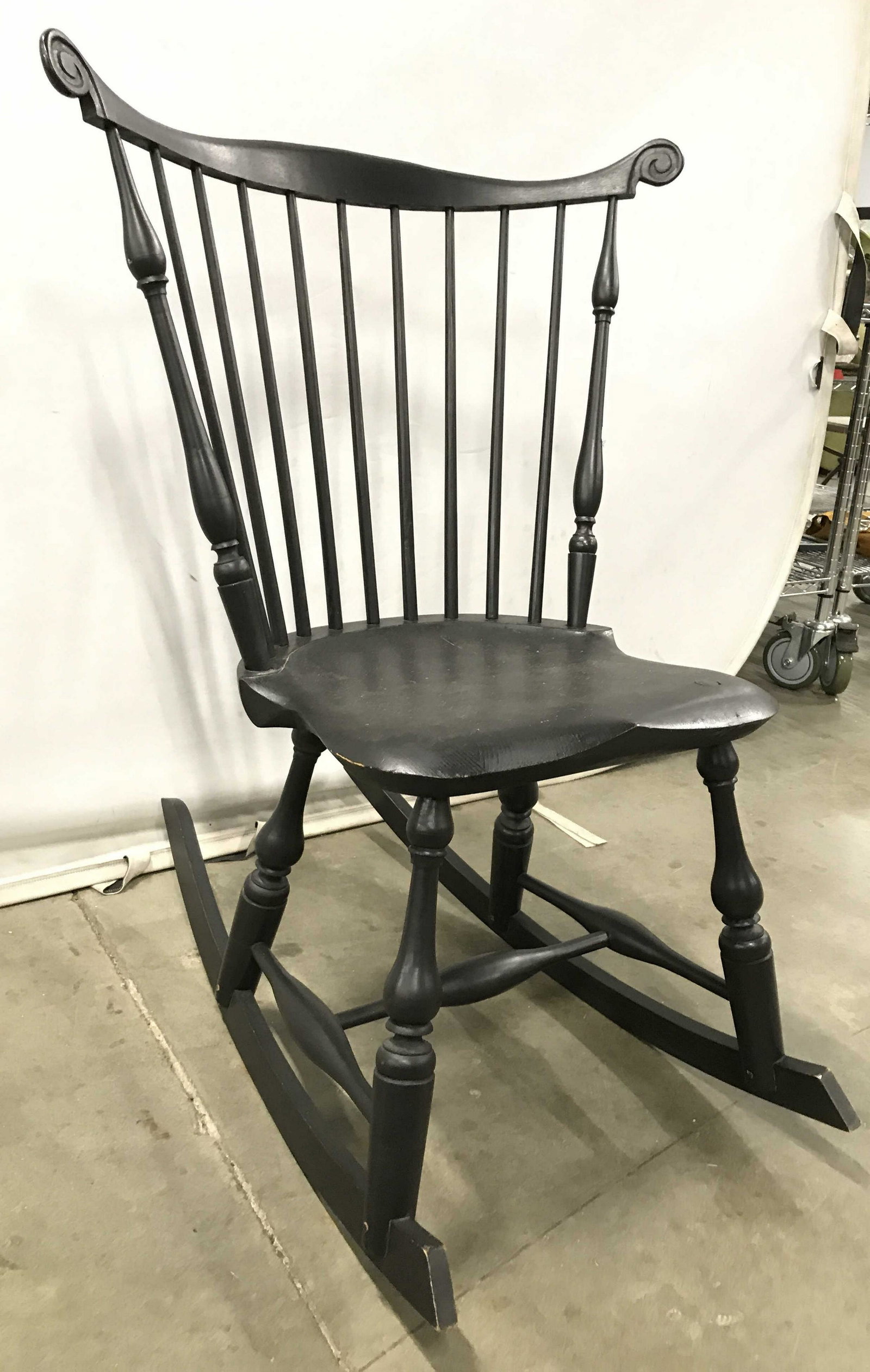 Vintage Wooden Black Toned Rocking Chair: Rocking chair is vintage. Piece is black toned and wooden. Chair has spindle back rest. Chair, rocking chair, wooden rocking chair, vintage rocking Chair,. Piece measures approximately 37 inches wide.