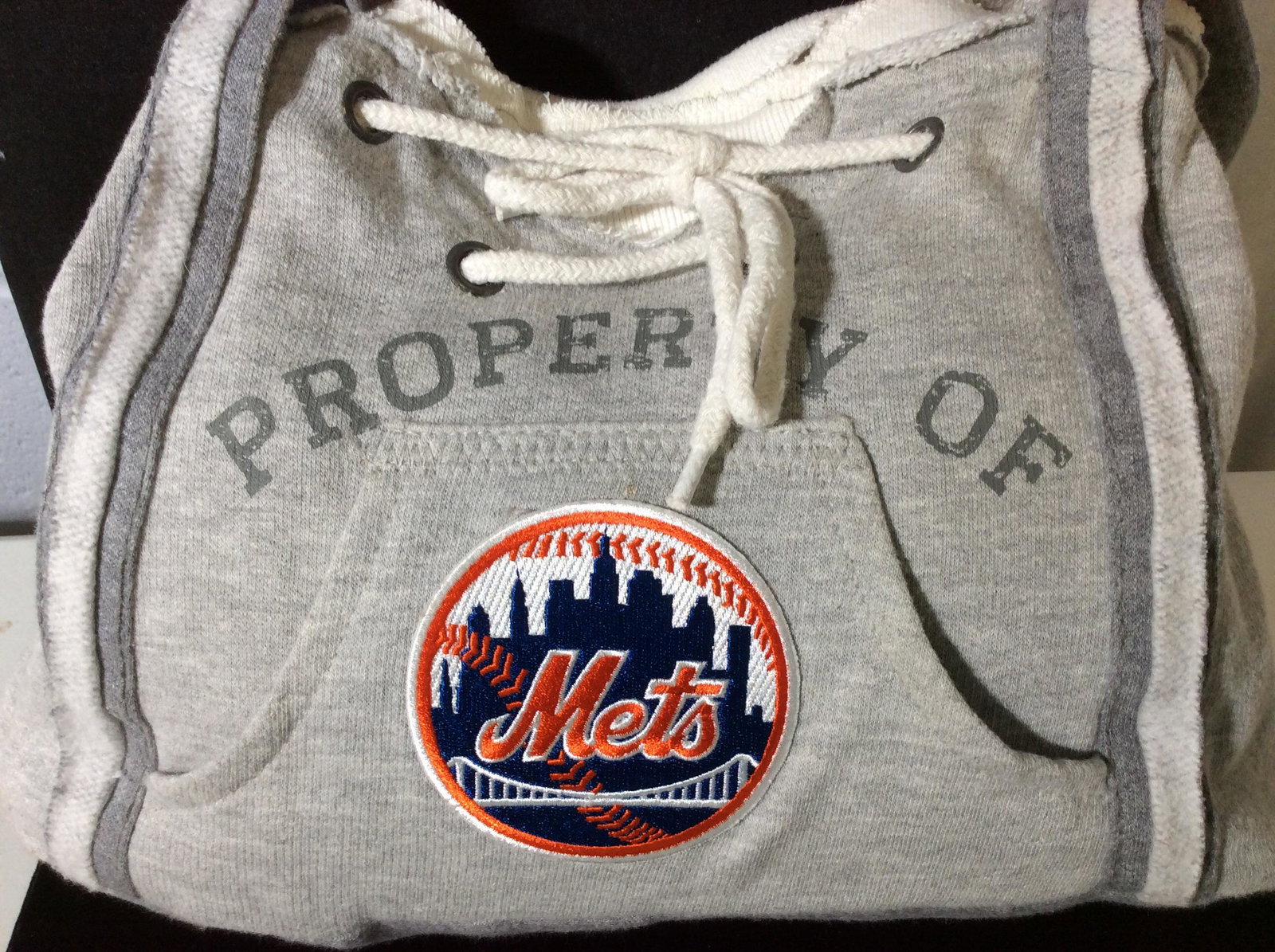 Official METS Sports Fan Jersey Handbag: Genuine METS Accessory Merchandise , MLB Trademark label attached. Mets Patch with NYC skyline on front. Grey jersey, 70% cotton, 30% Polyester. Lining black linen cotton. Cord cinch and snap closure.