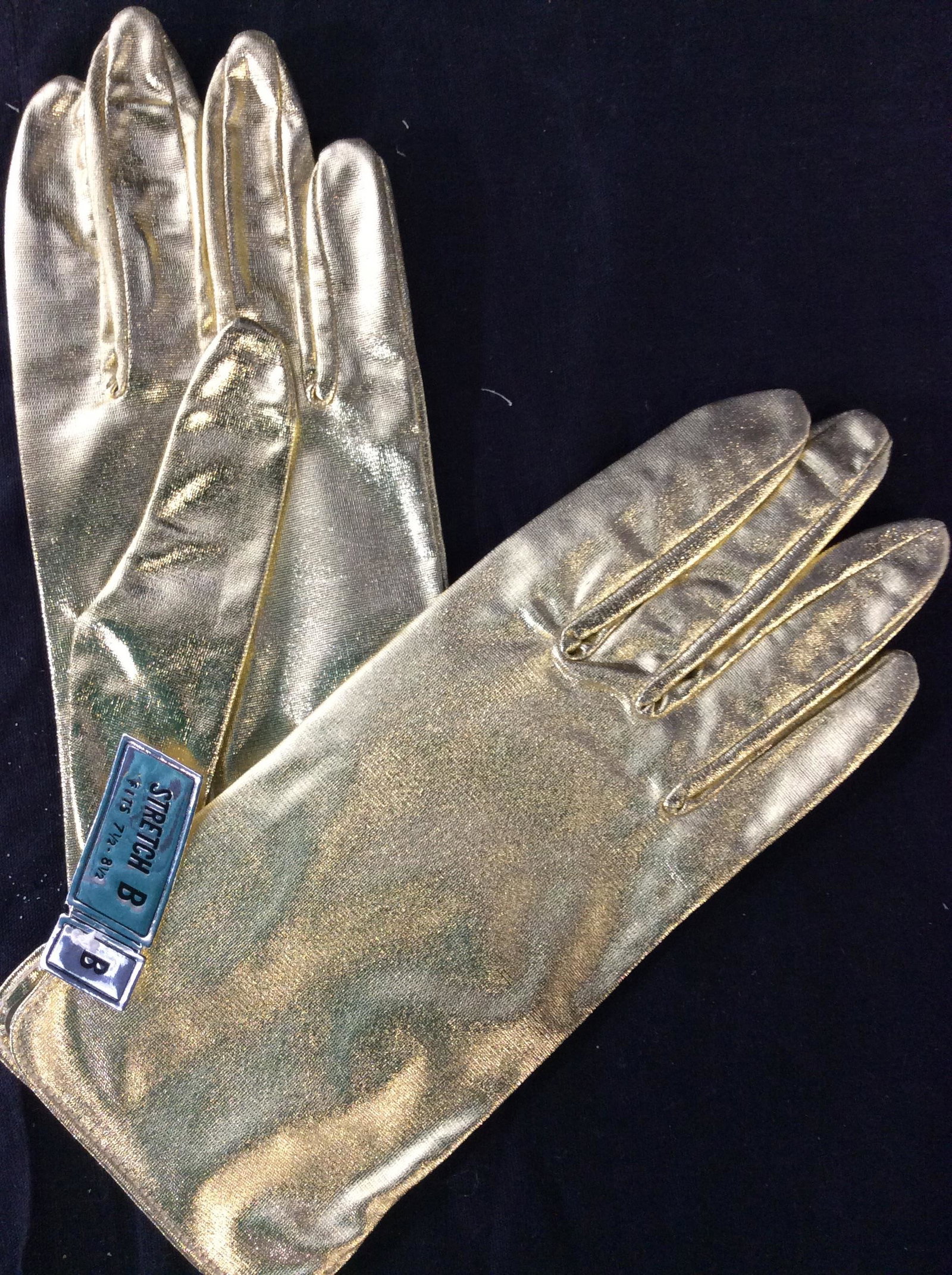 Pair Silver + Gold Metallic Fashion Gloves, New: Stretch B, fits 7.5-8.5 hand size. Has stretch. Nylon and metallic fabric. Never used. In original plastic package. Fashion Gloves, Costume Accessory, Ladies Fashion Accessory, Metallic Gold Silver Gl